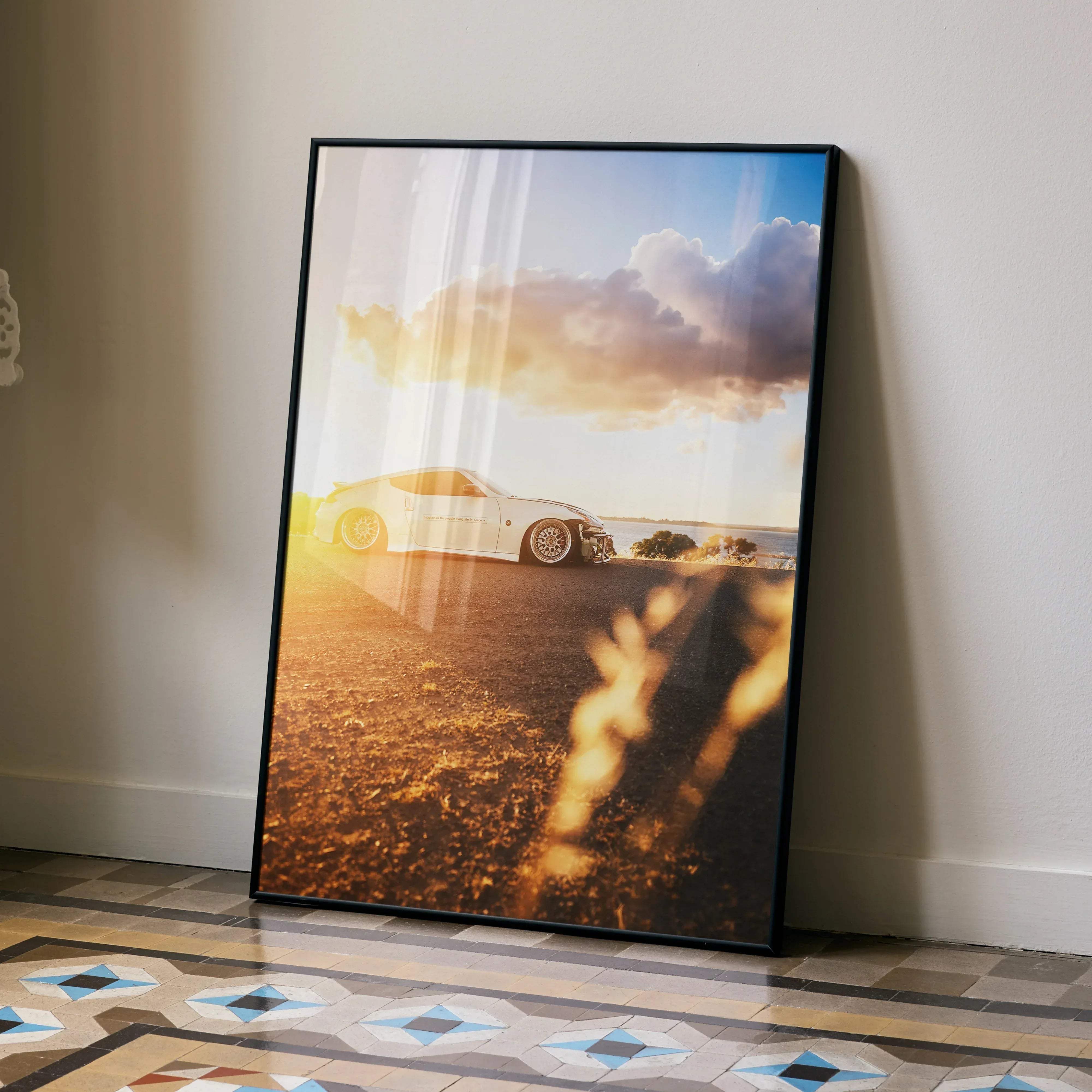 Black-framed Nissan 370z high resolution car poster featuring a white sports car under golden sunset skies