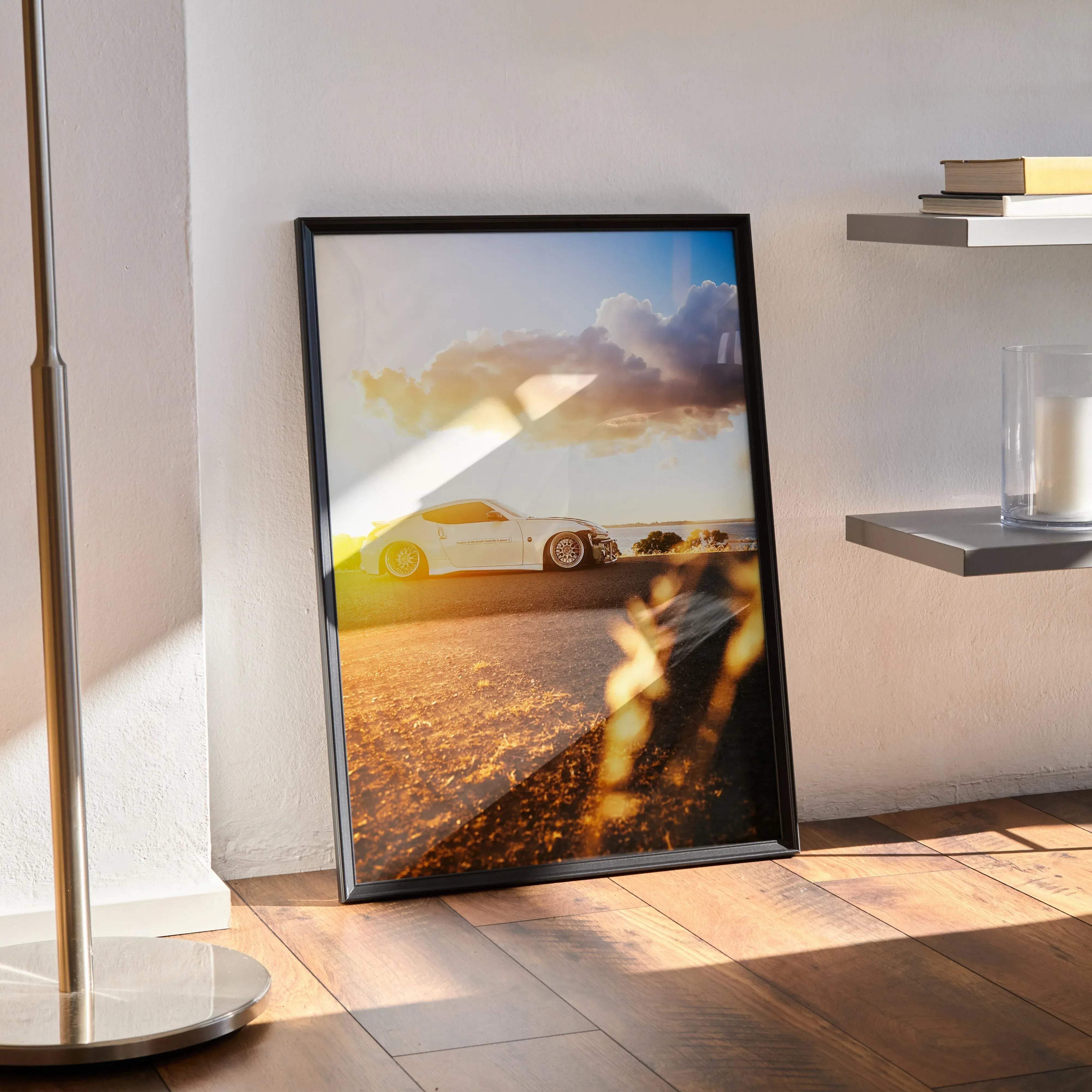 Black-framed poster featuring a white Nissan 370z sports car under a golden sunset with dramatic clouds