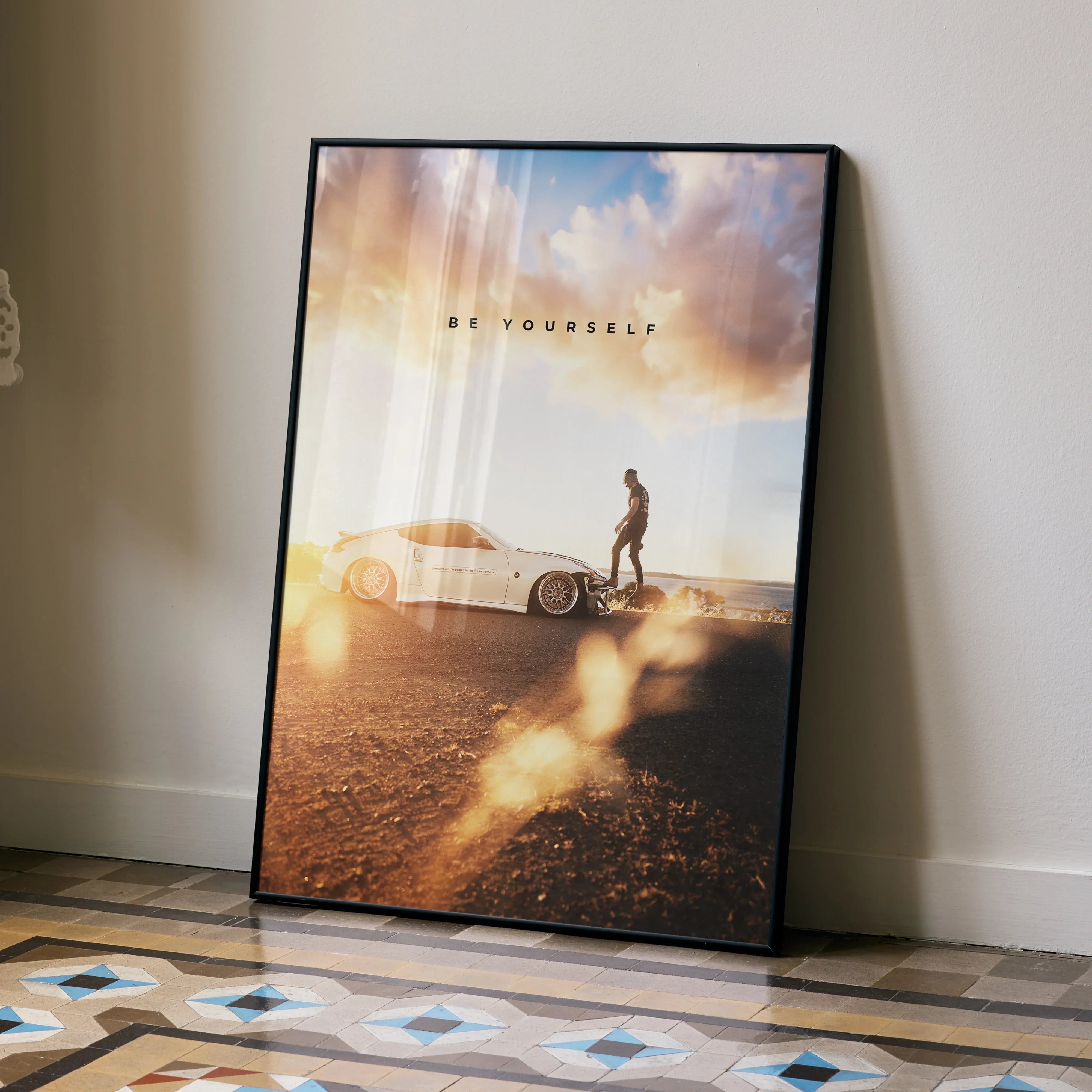Motivational poster wall art featuring a white Nissan 370z and a person walking at sunset.