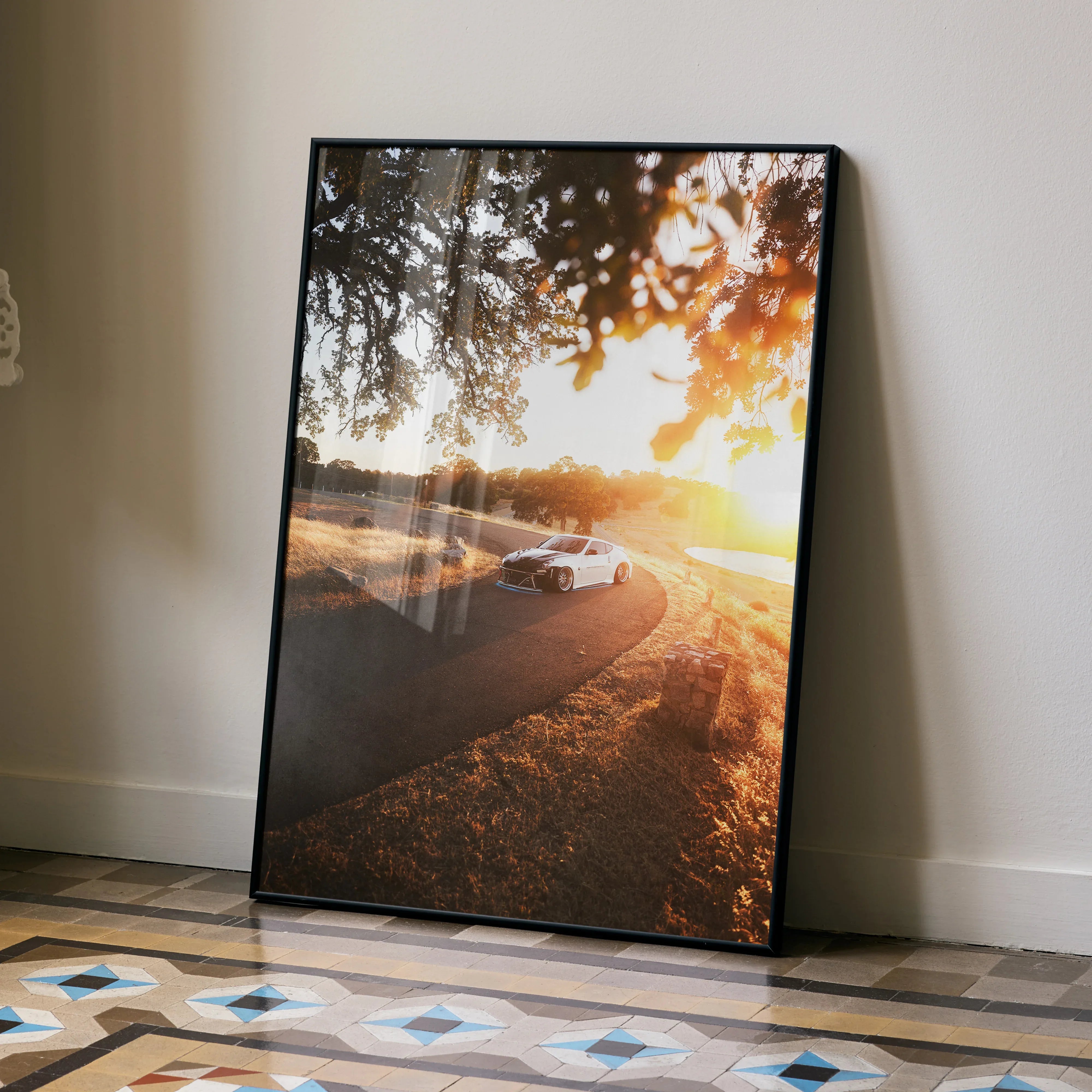 Nissan 370z Wall Art poster showing car on winding road at sunset with golden light filtering through trees.