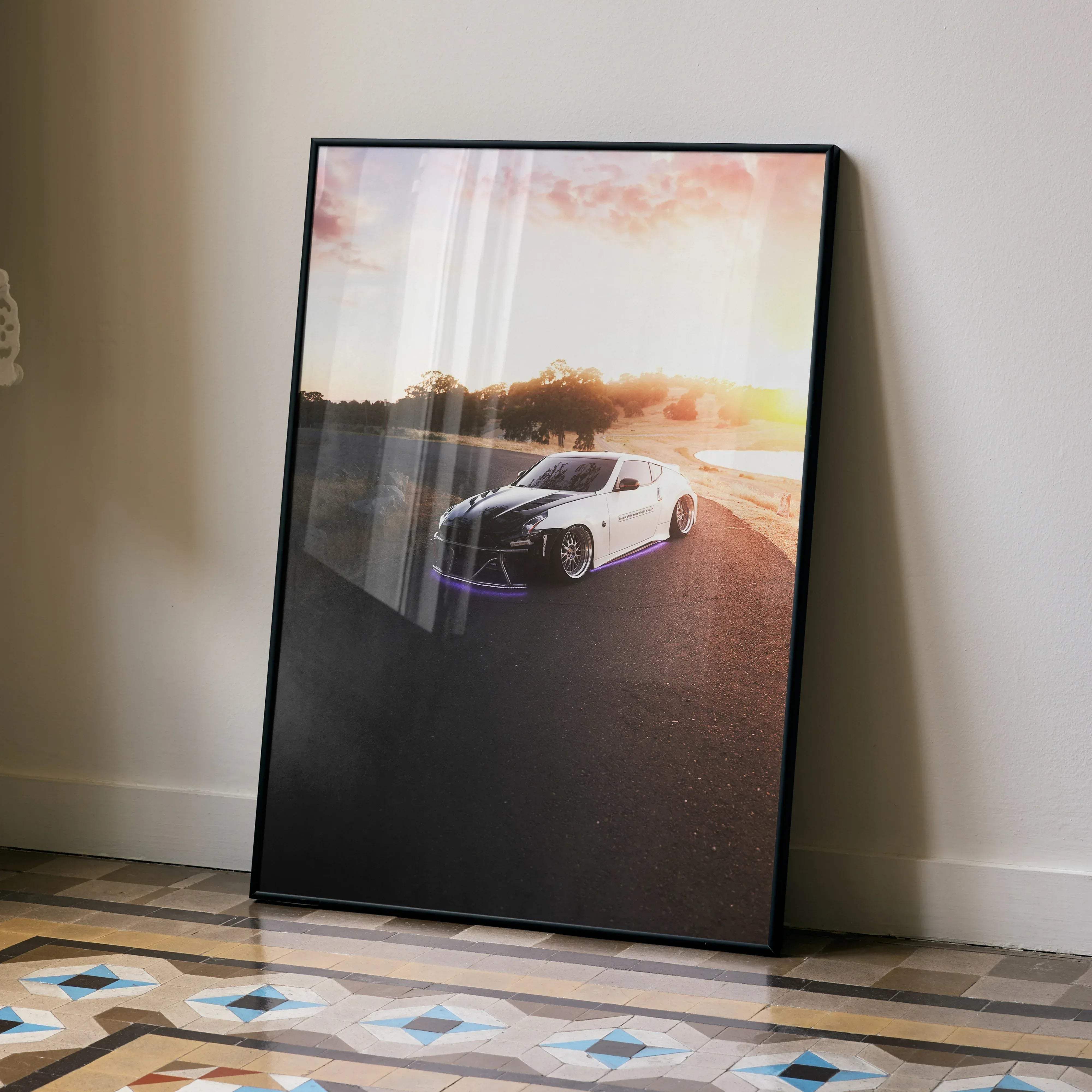 Black-framed poster of a white and black aston martin sports car with purple underglow and sunset backdrop for nissan 370z fans