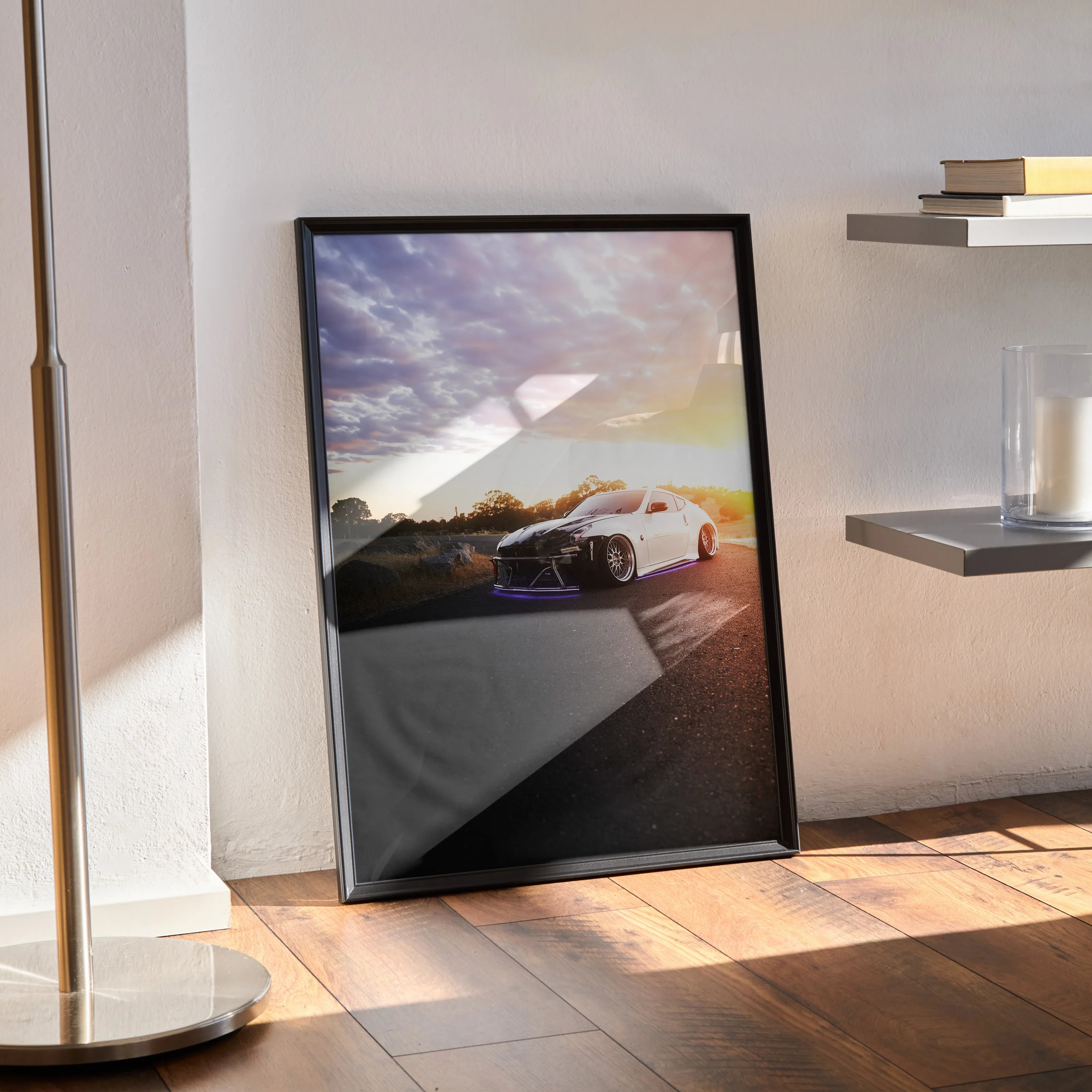 Nissan 370z poster with sunset backdrop leaning against wall, modern wall art in black frame.