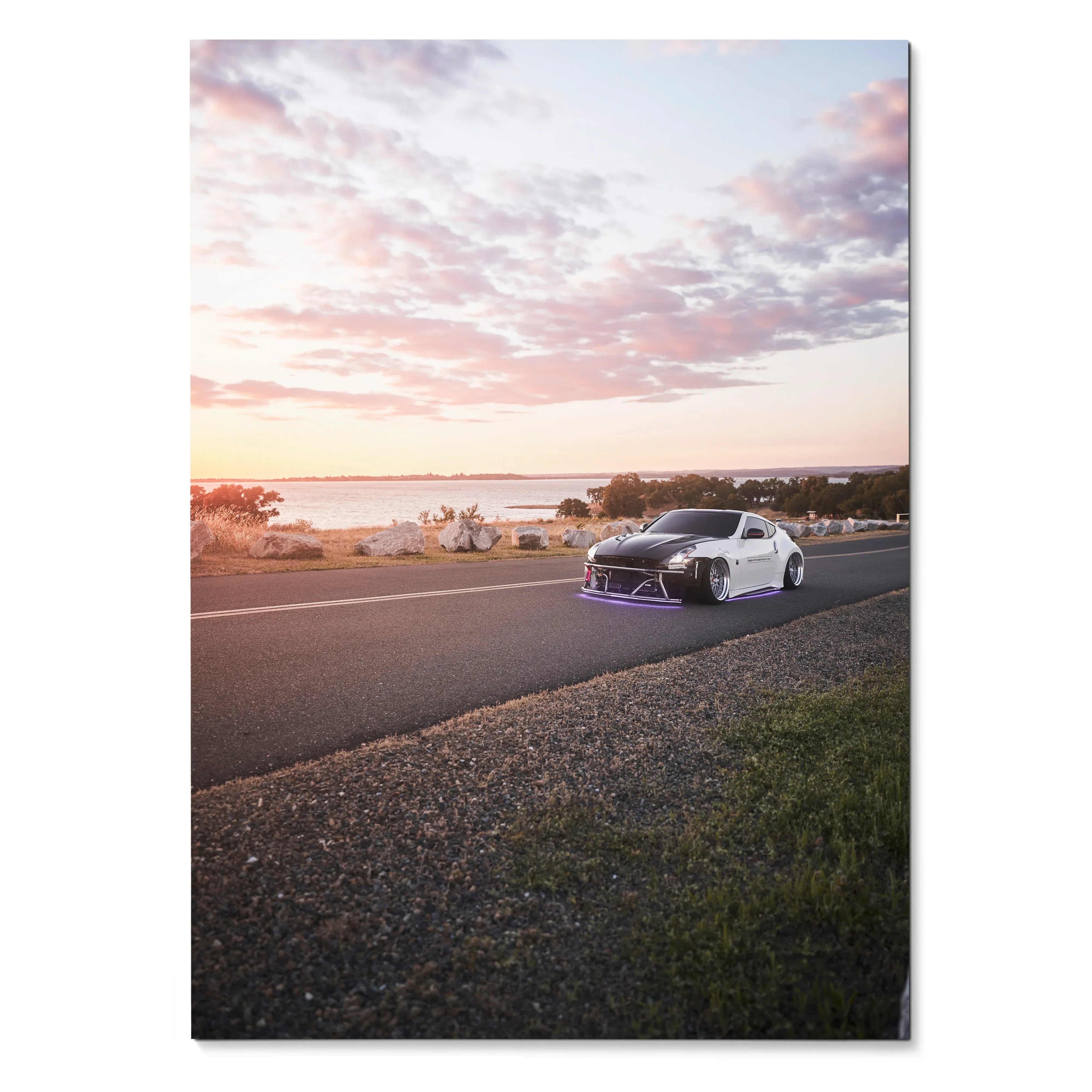Nissan 370z driving on coastal road at sunset poster wall art with pink clouds and ocean view.