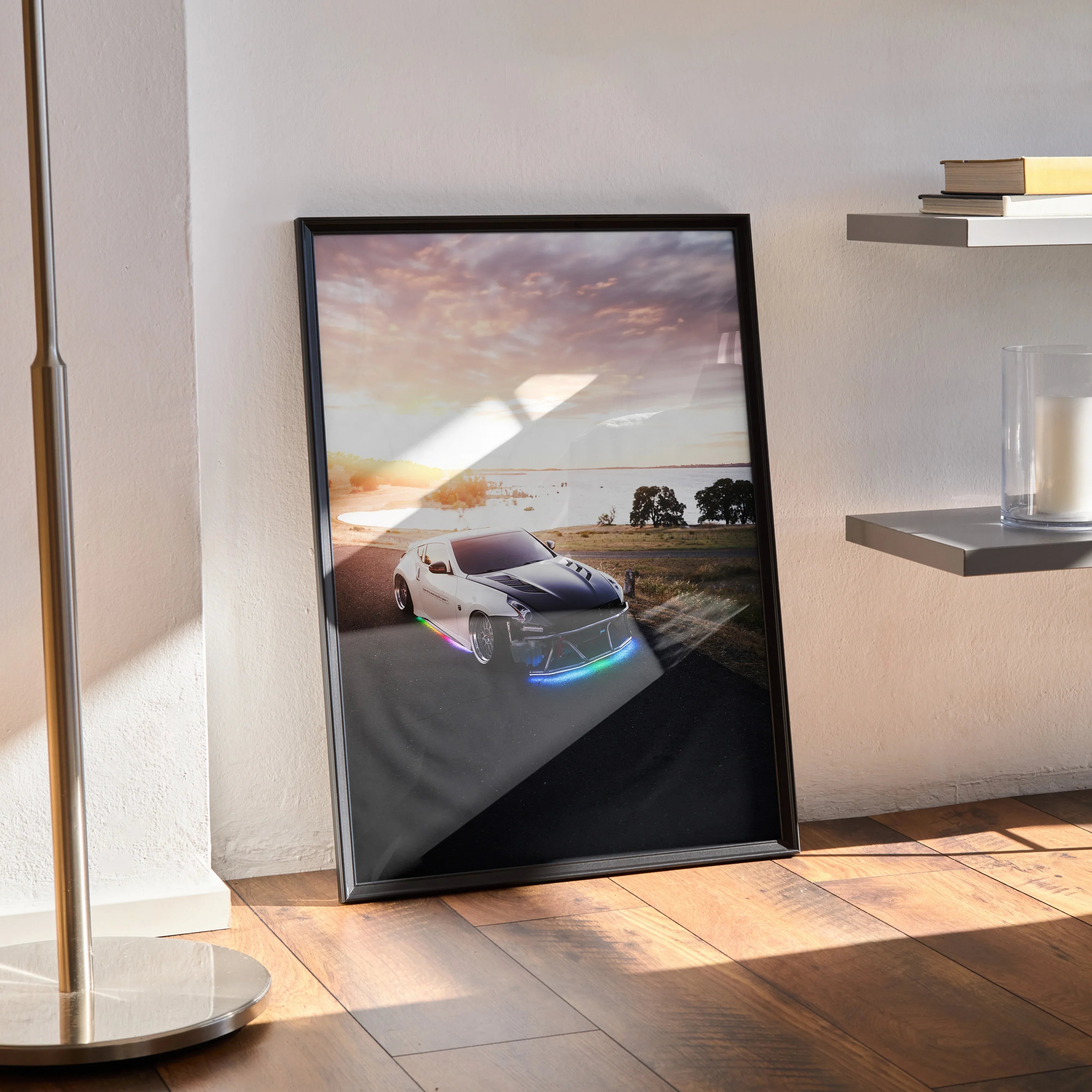 Nissan 370z car poster with sunset road scene leaning against wall, modern black frame wall art.