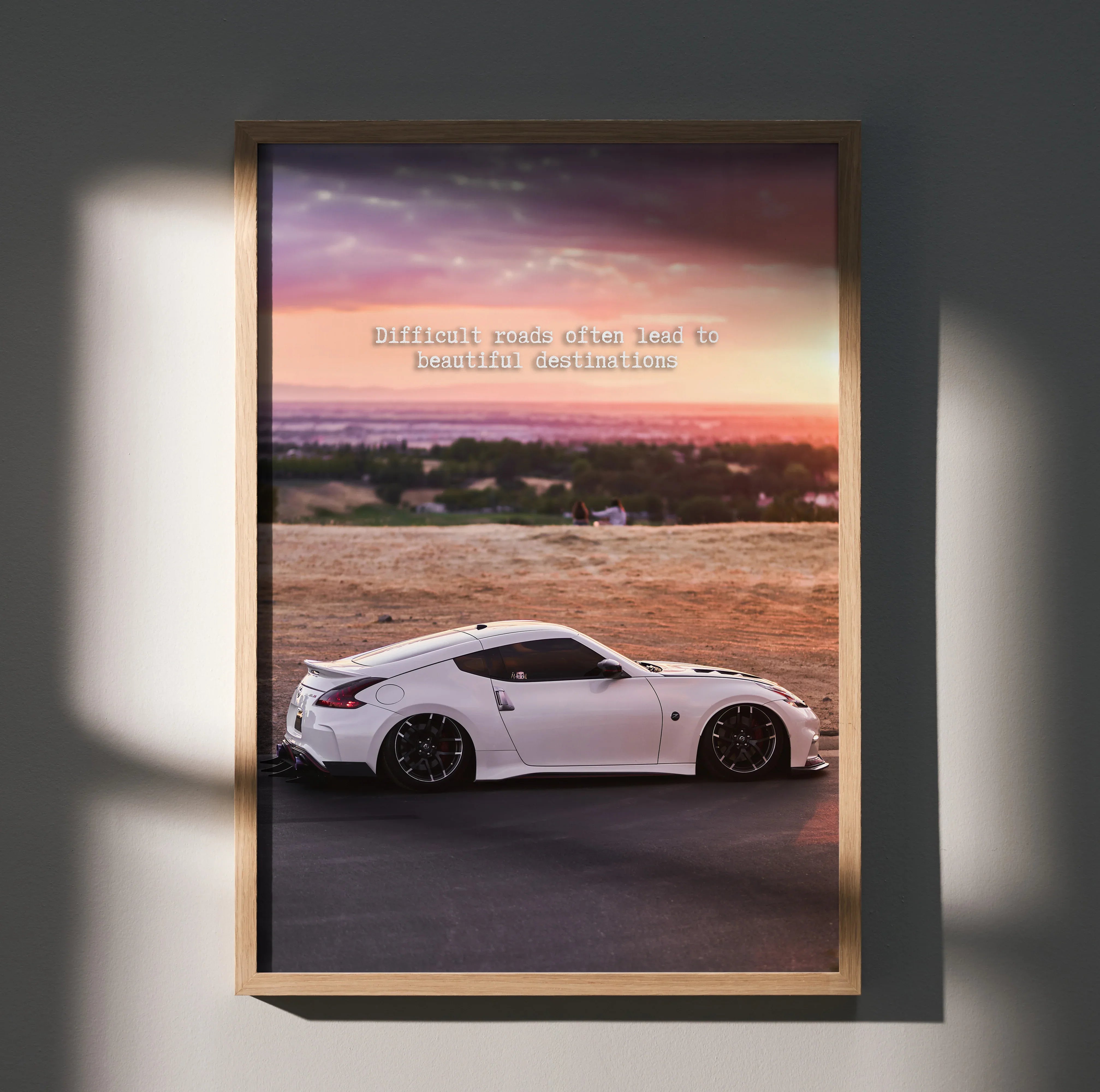 Motivational poster wall art featuring white Nissan 370z car with sunset and inspiring text.