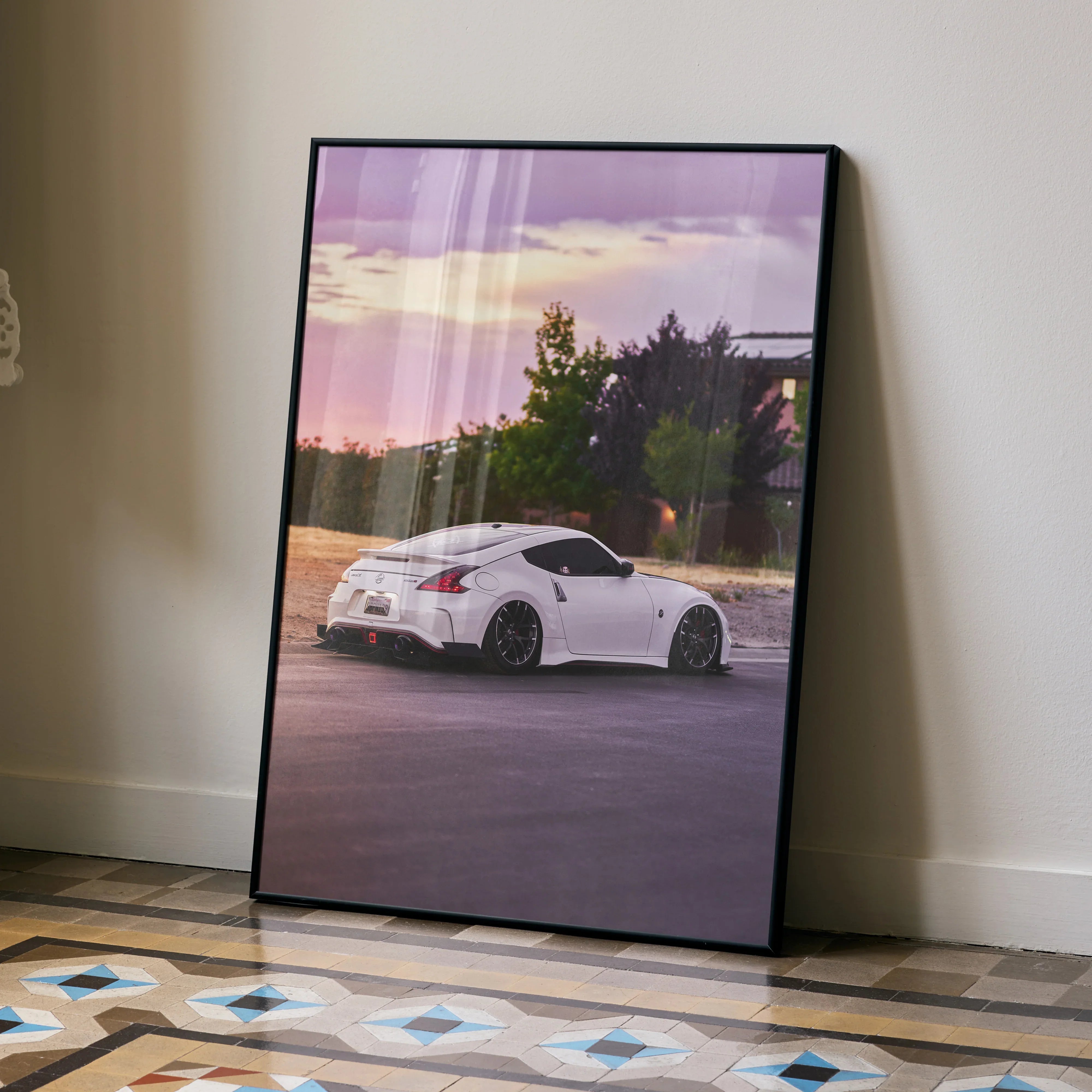Nissan 370z poster with white car parked at sunset, framed wall art with purple sky and trees.