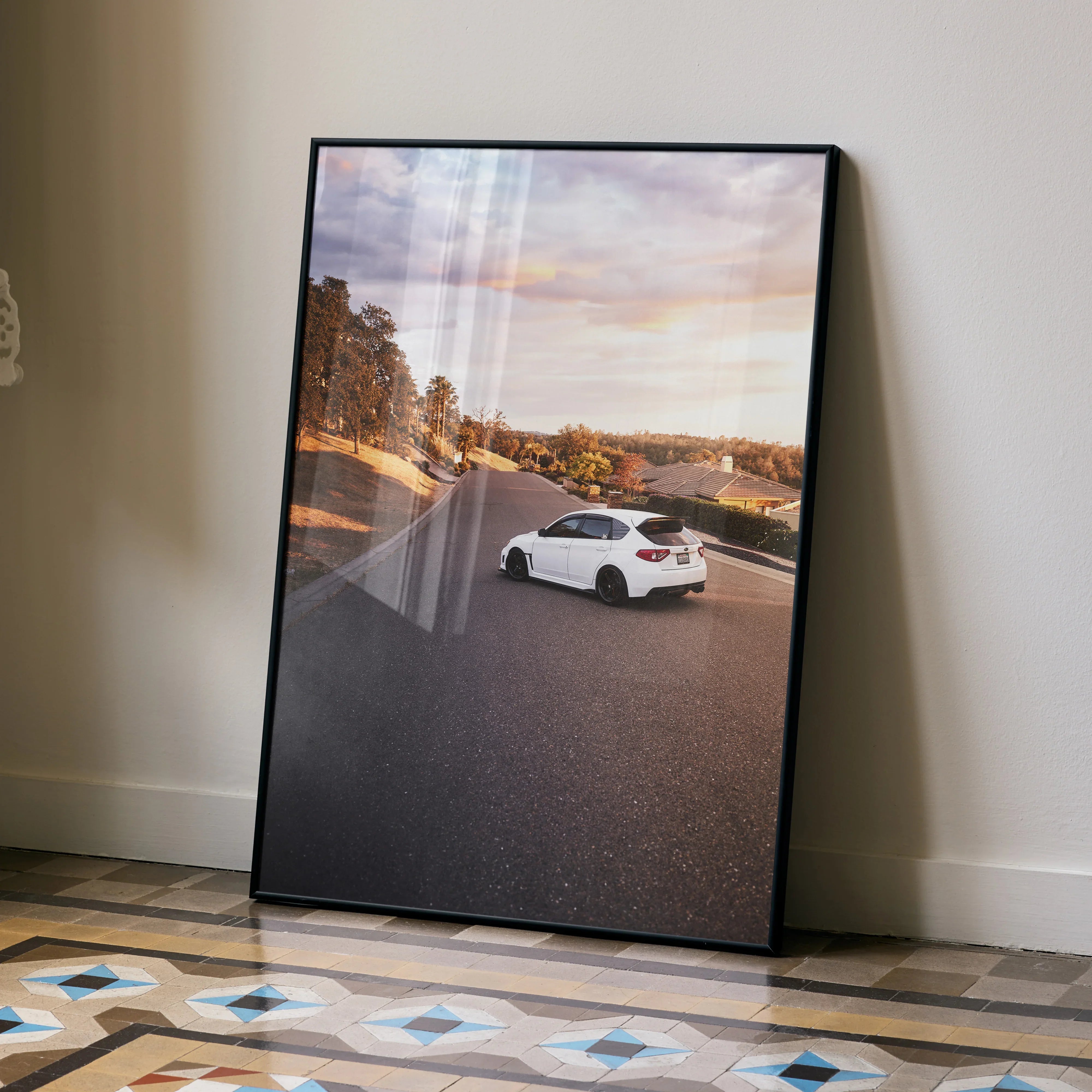 Subaru WRX STI white car driving on road at sunset poster wall art with scenic background.