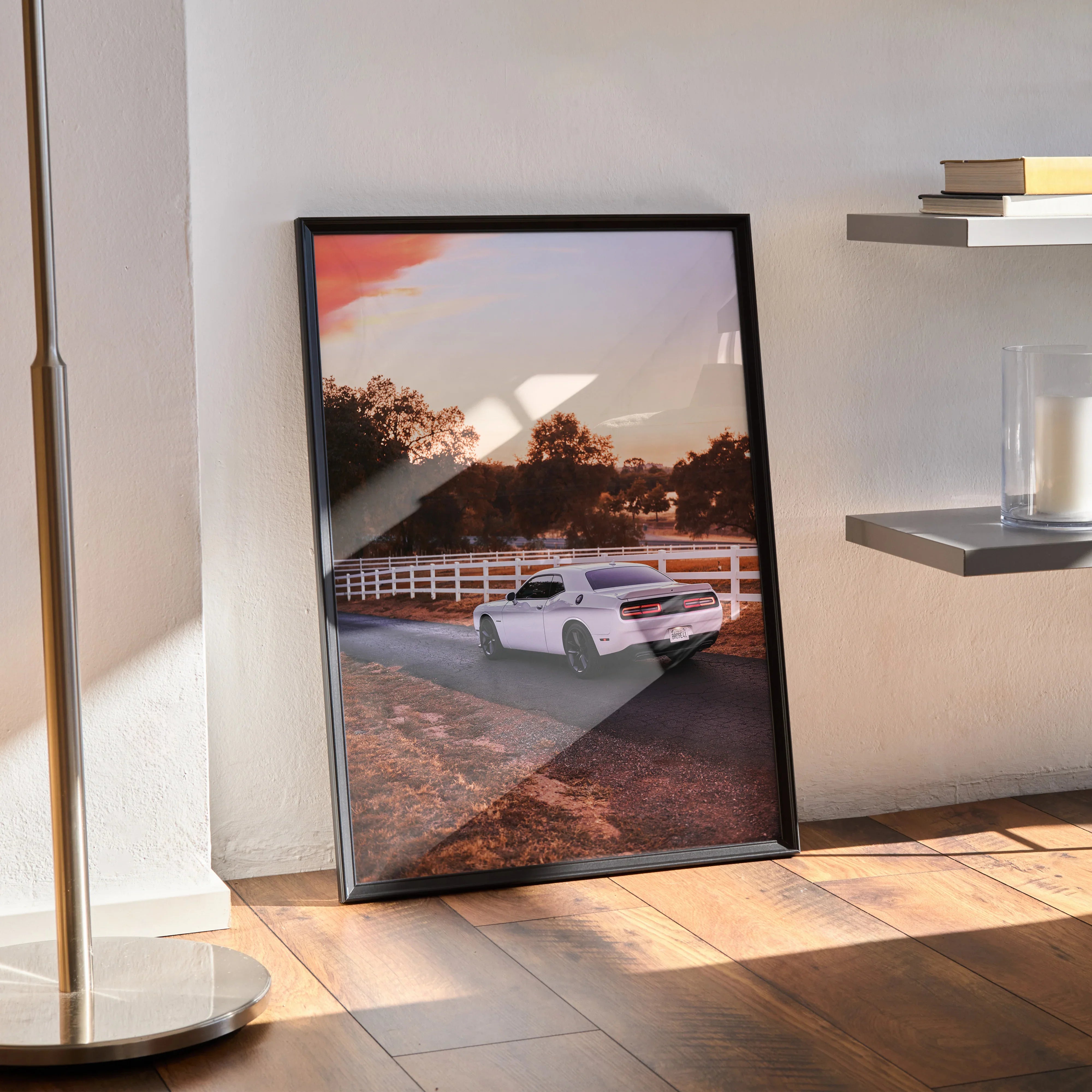 Dodge Challenger poster wall art with white muscle car on rural road at sunset in black frame.