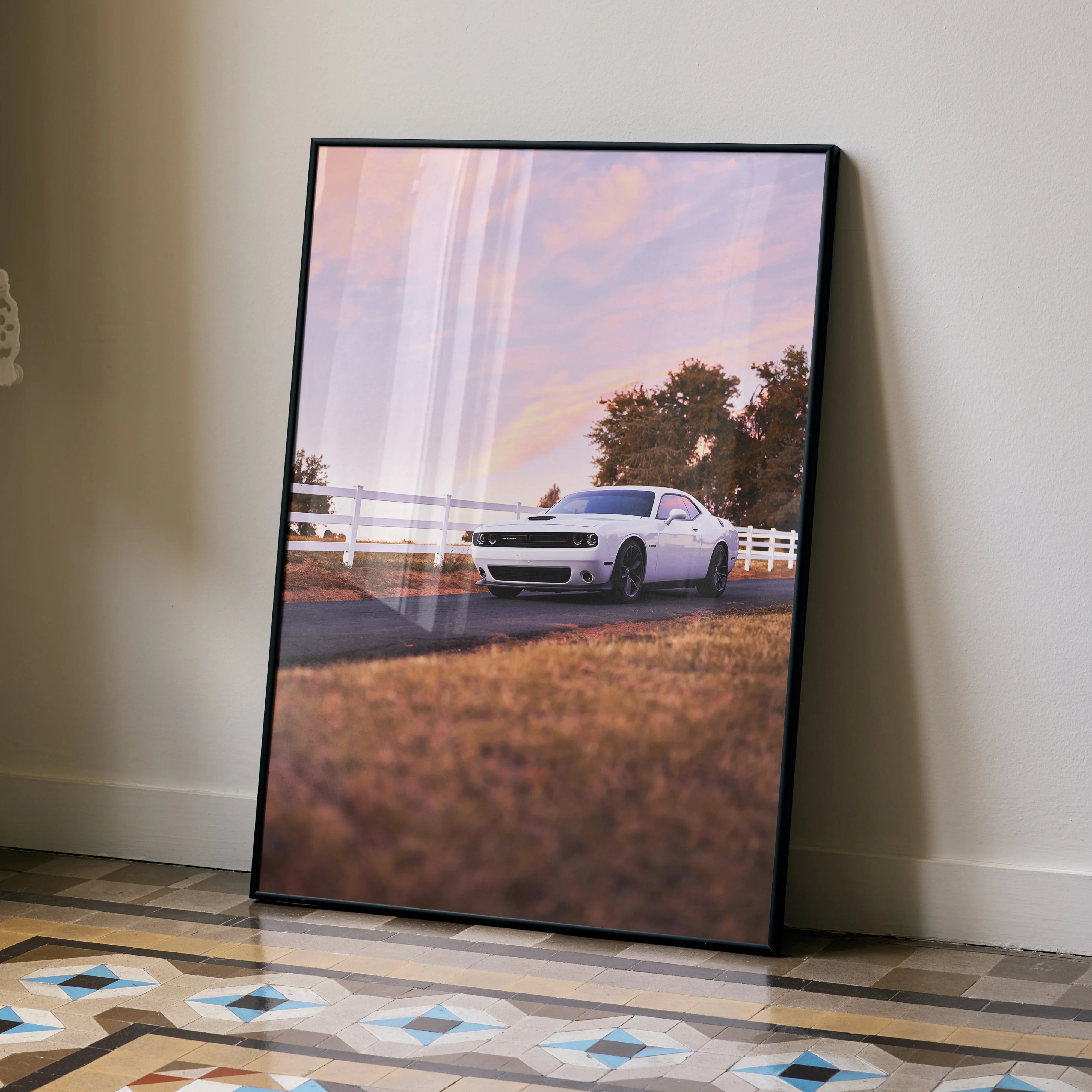 Dodge Challenger parked on country road at sunset poster wall art in black frame.