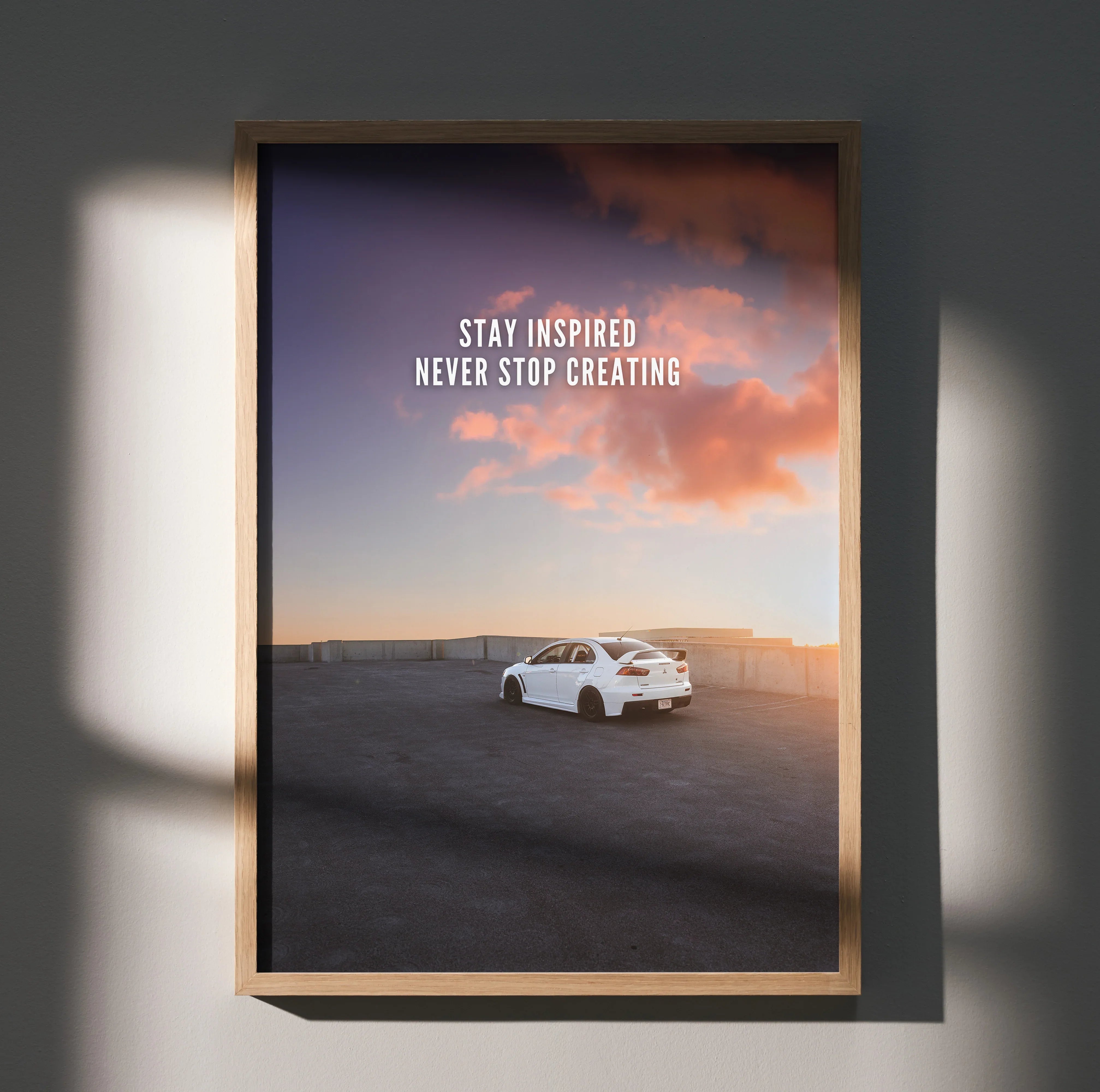 Motivational poster wall art with white Mitsubishi Evo 10 under vibrant sunset sky and inspiring text.