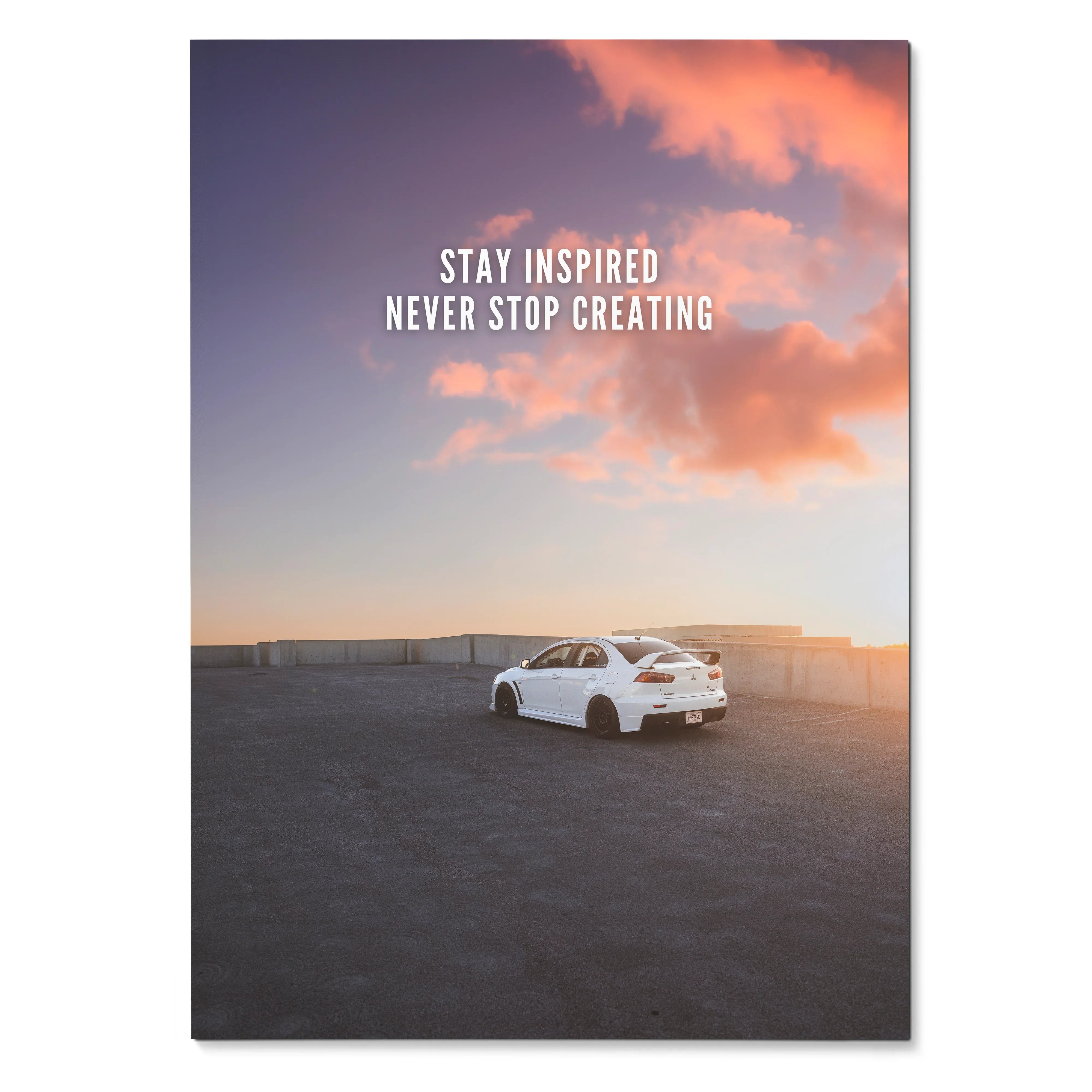 Motivational poster wall art with white Mitsubishi Evo 10 under pink sunset sky and inspiring text.