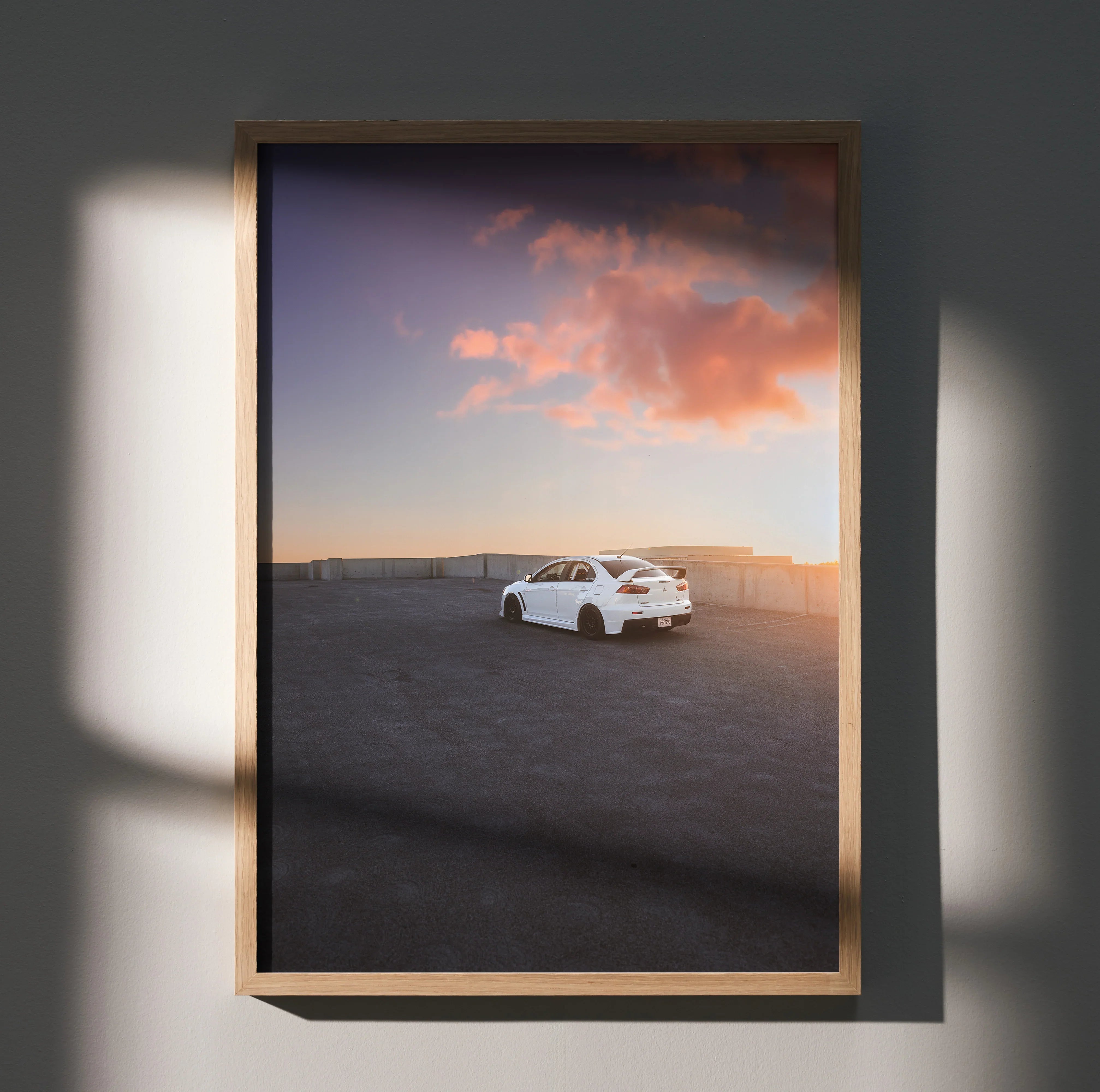 Mitsubishi Evo 10 poster wall art with white sports car at sunset and colorful sky in wooden frame.