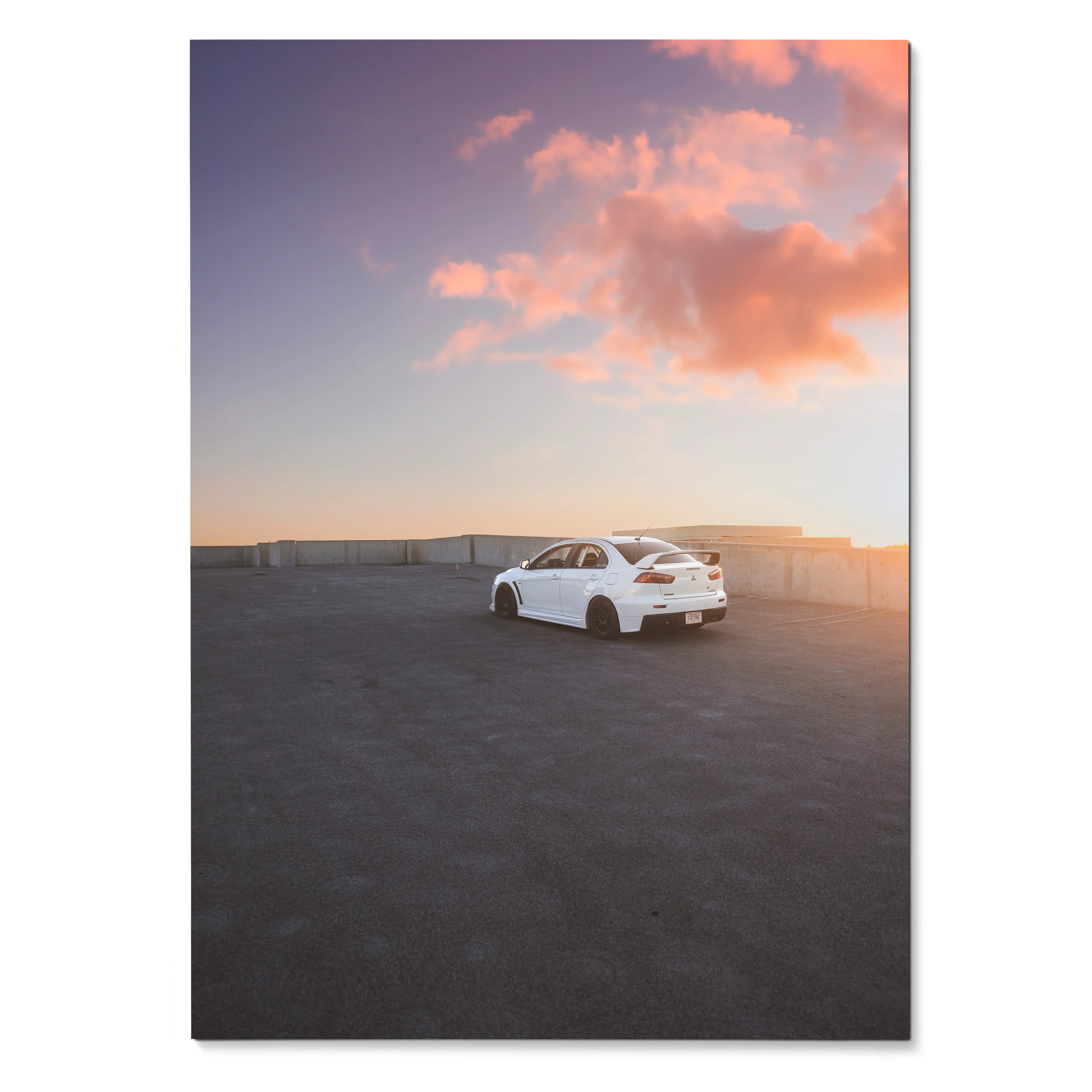 White Mitsubishi Evo 10 parked on rooftop at sunset with pink clouds poster wall art.