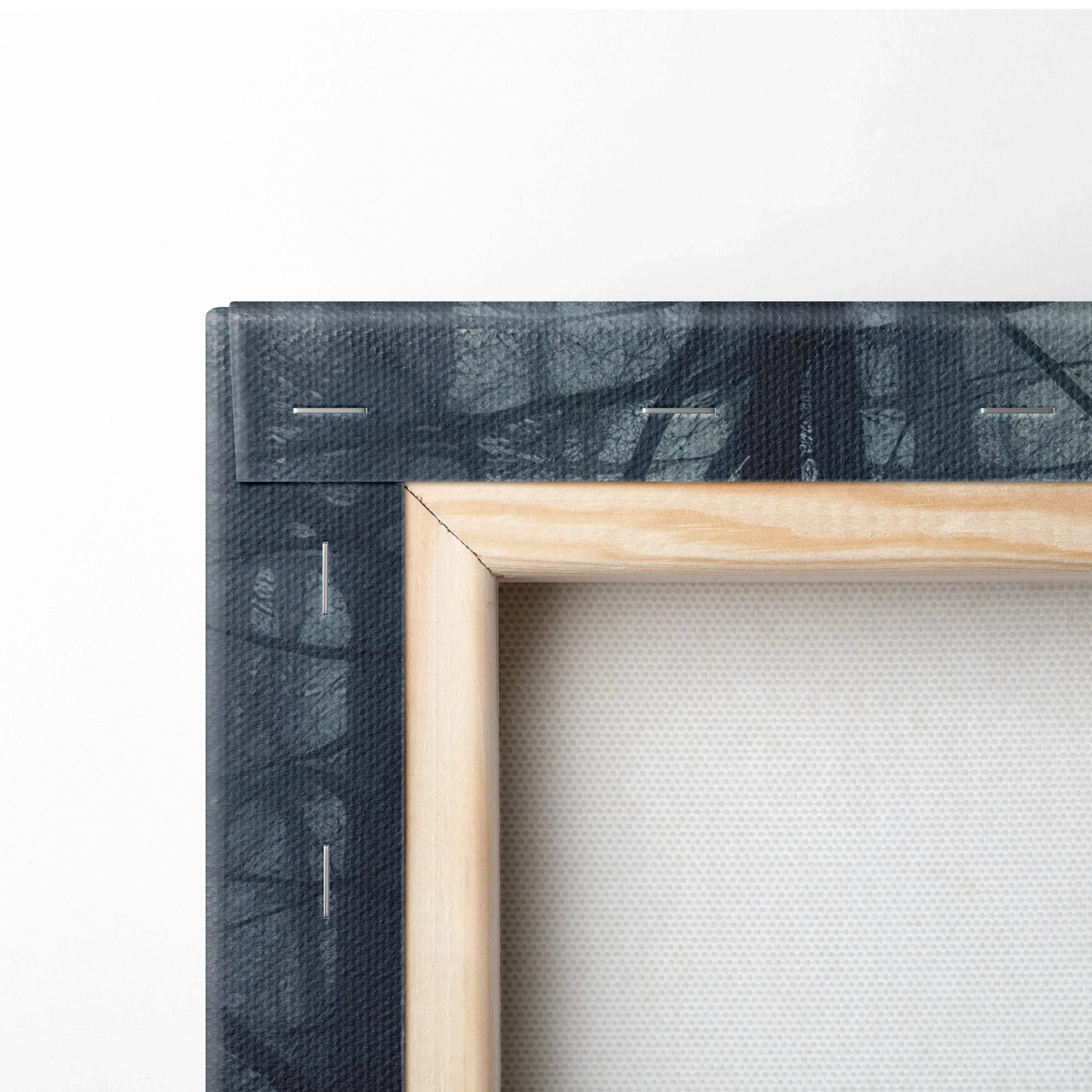 Light-colored wooden frame showing the back of moody atmospheric forest canvas wall art with dark textured canvas