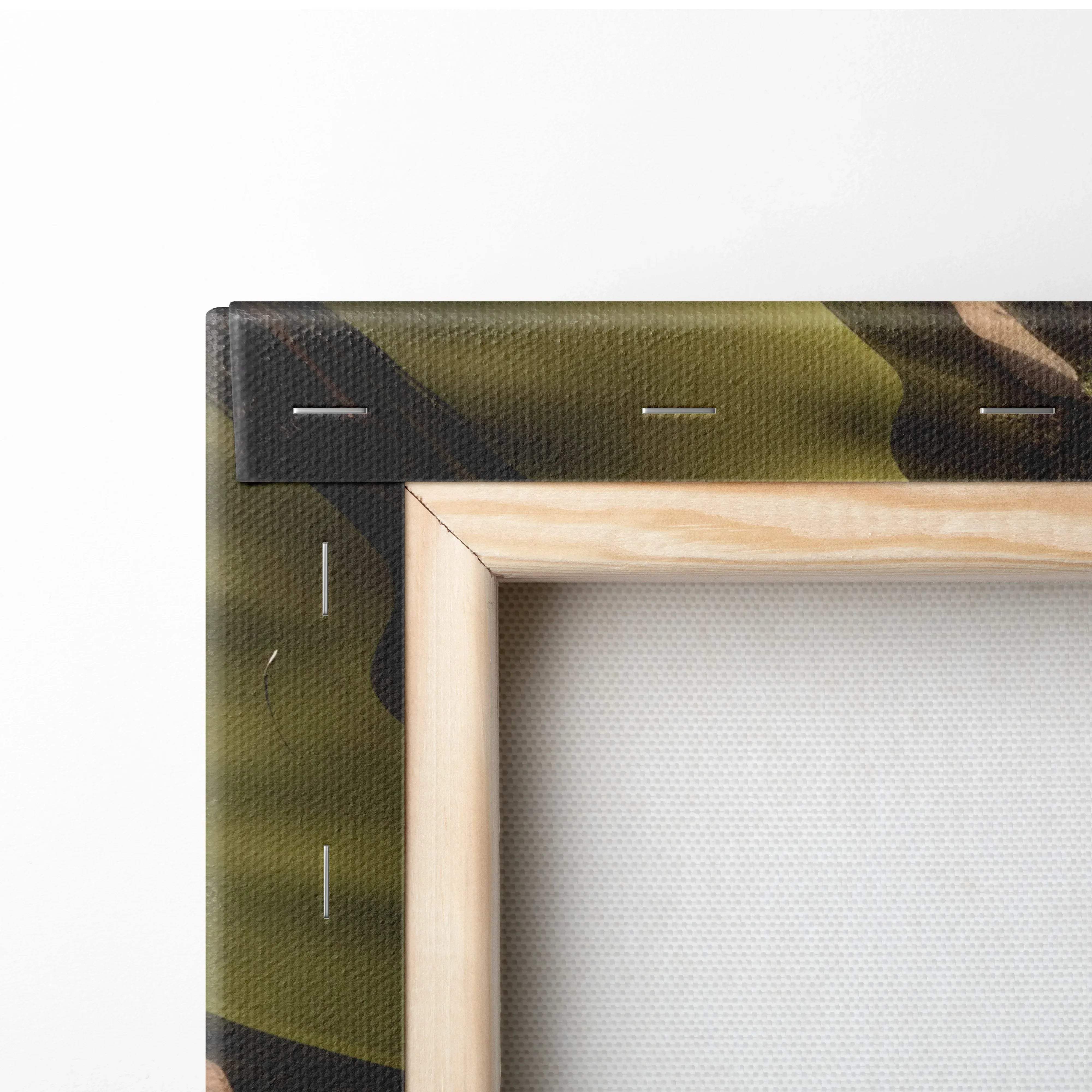 A framed canvas wall art with olive green and black camouflage pattern on textured fabric over light wood frame