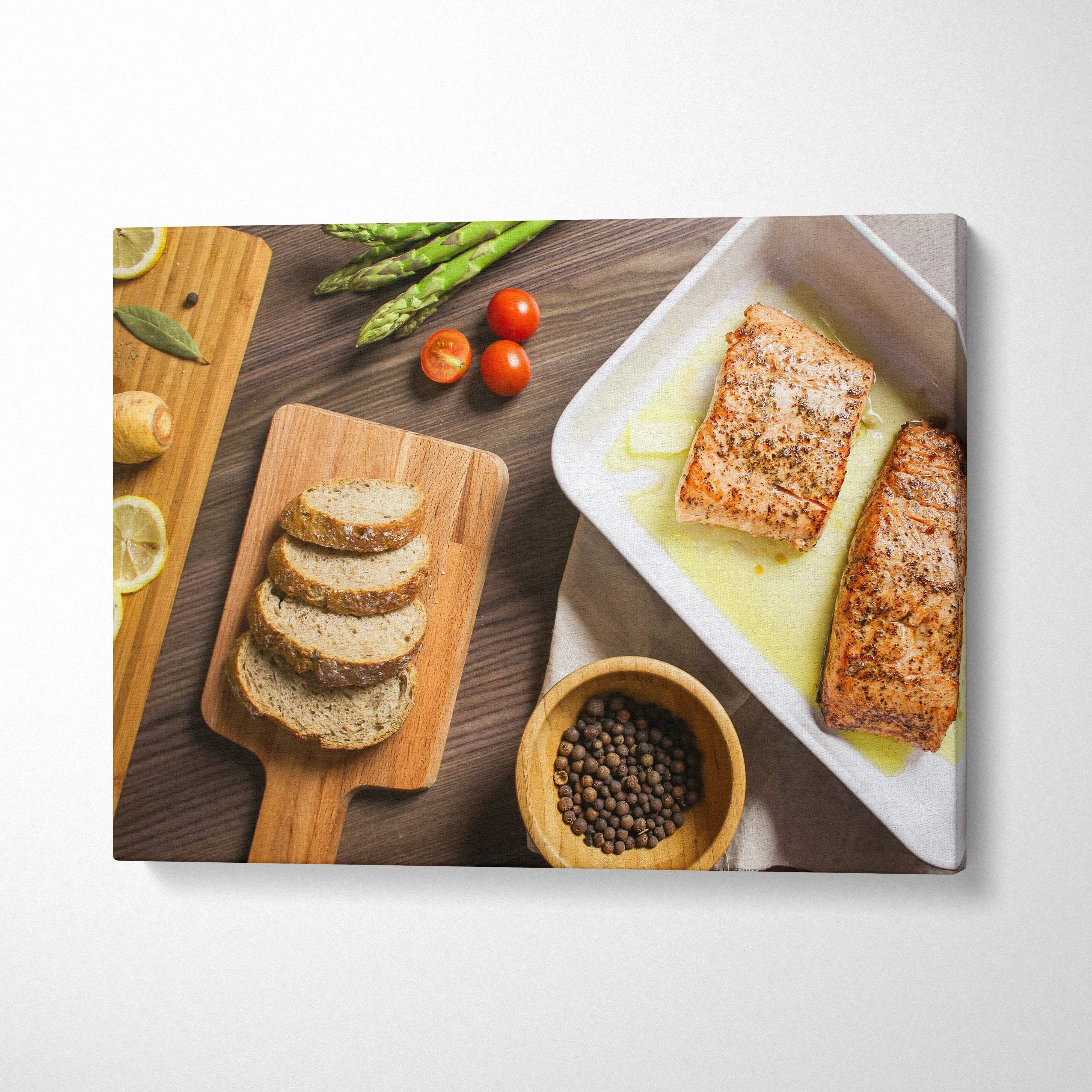 Canvas wall art featuring a lunch table scene with grilled salmon, sliced bread, asparagus, and cherry tomatoes decor.