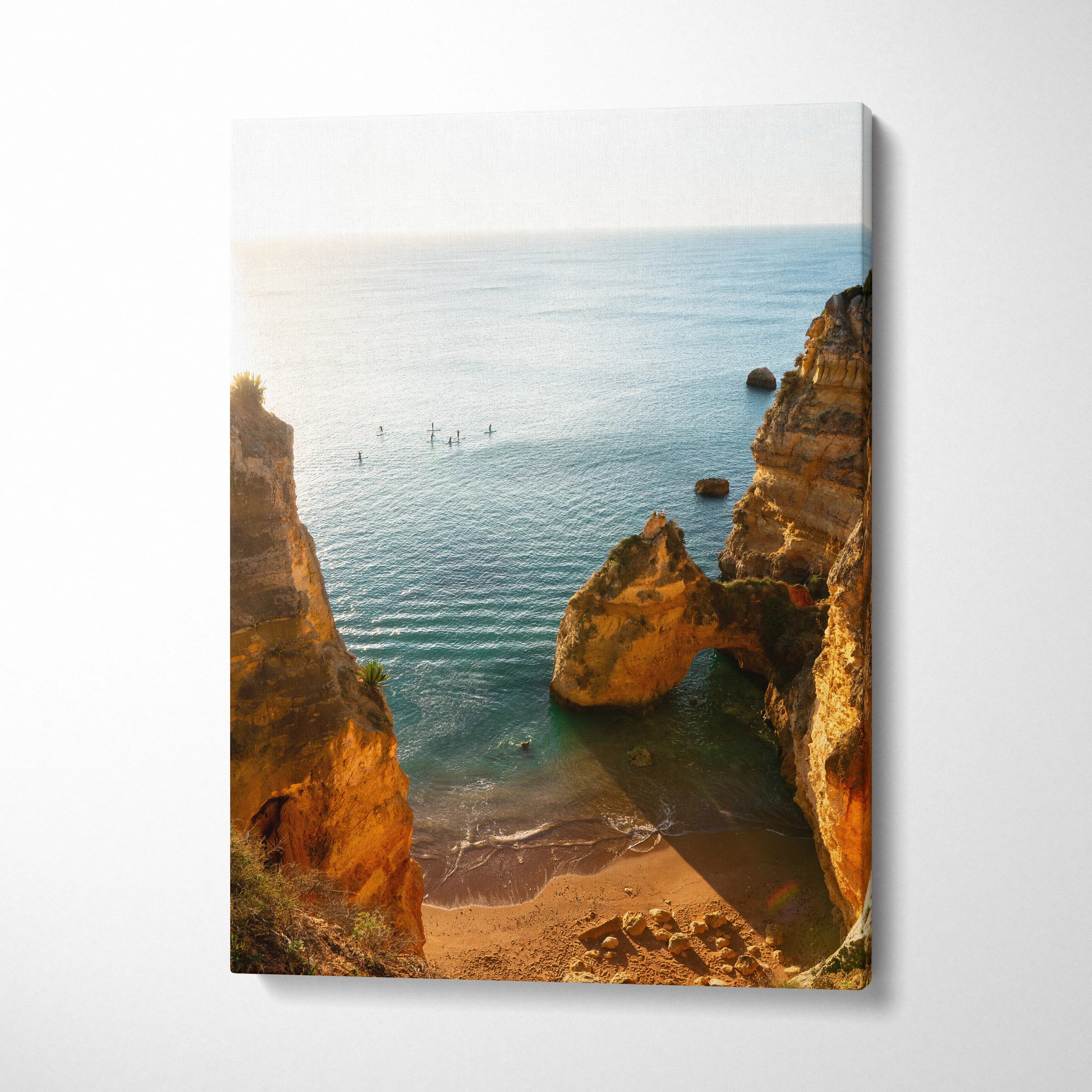 Canvas wall art featuring a sunlit beach scene with golden cliffs and calm blue water.