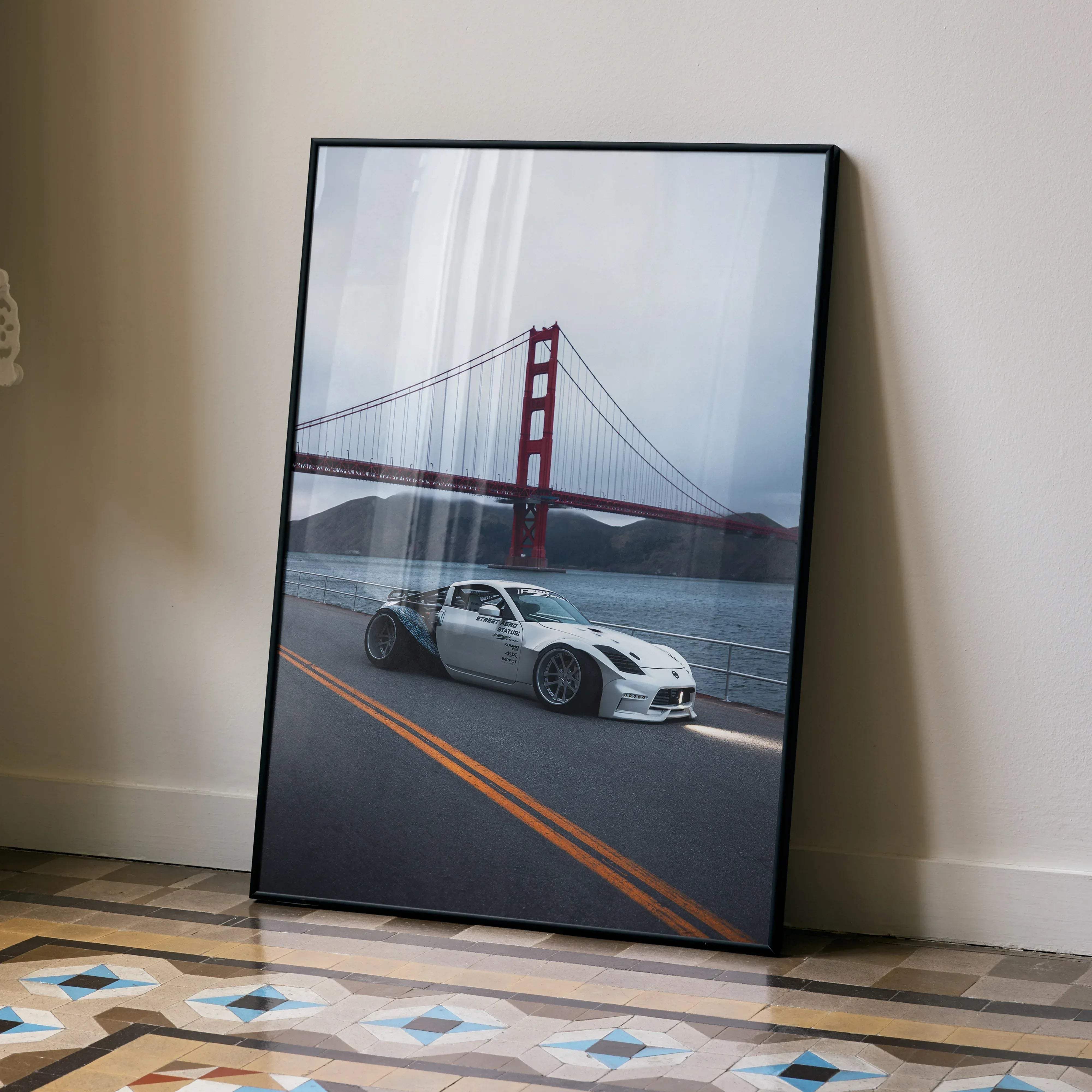 Black-framed poster of white Nissan 350z widebody drifting by the red golden gate bridge for premium wall decor