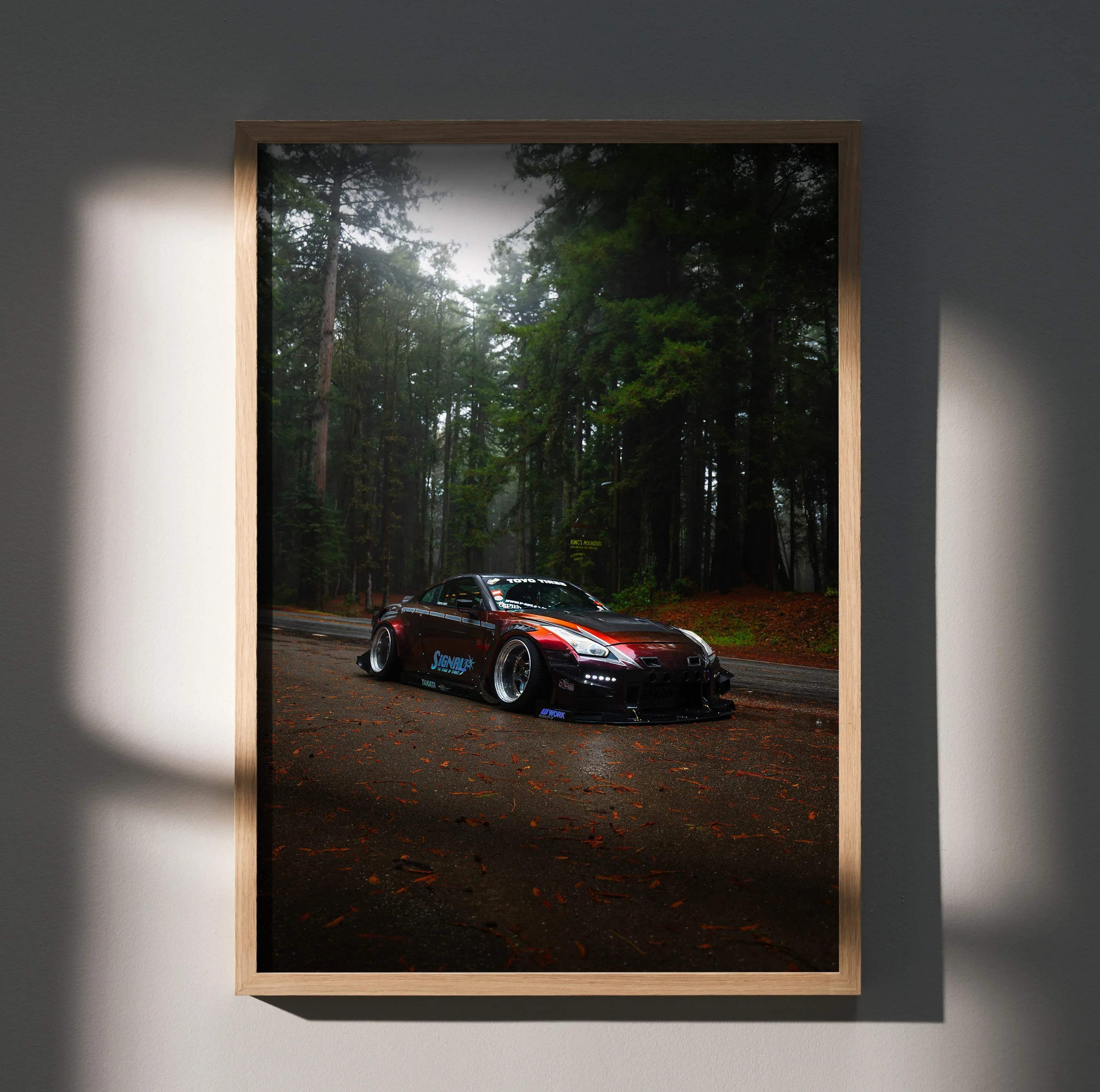 A framed red and black Nissan GT-R R35 art print poster showing the car drifting through a misty forest road