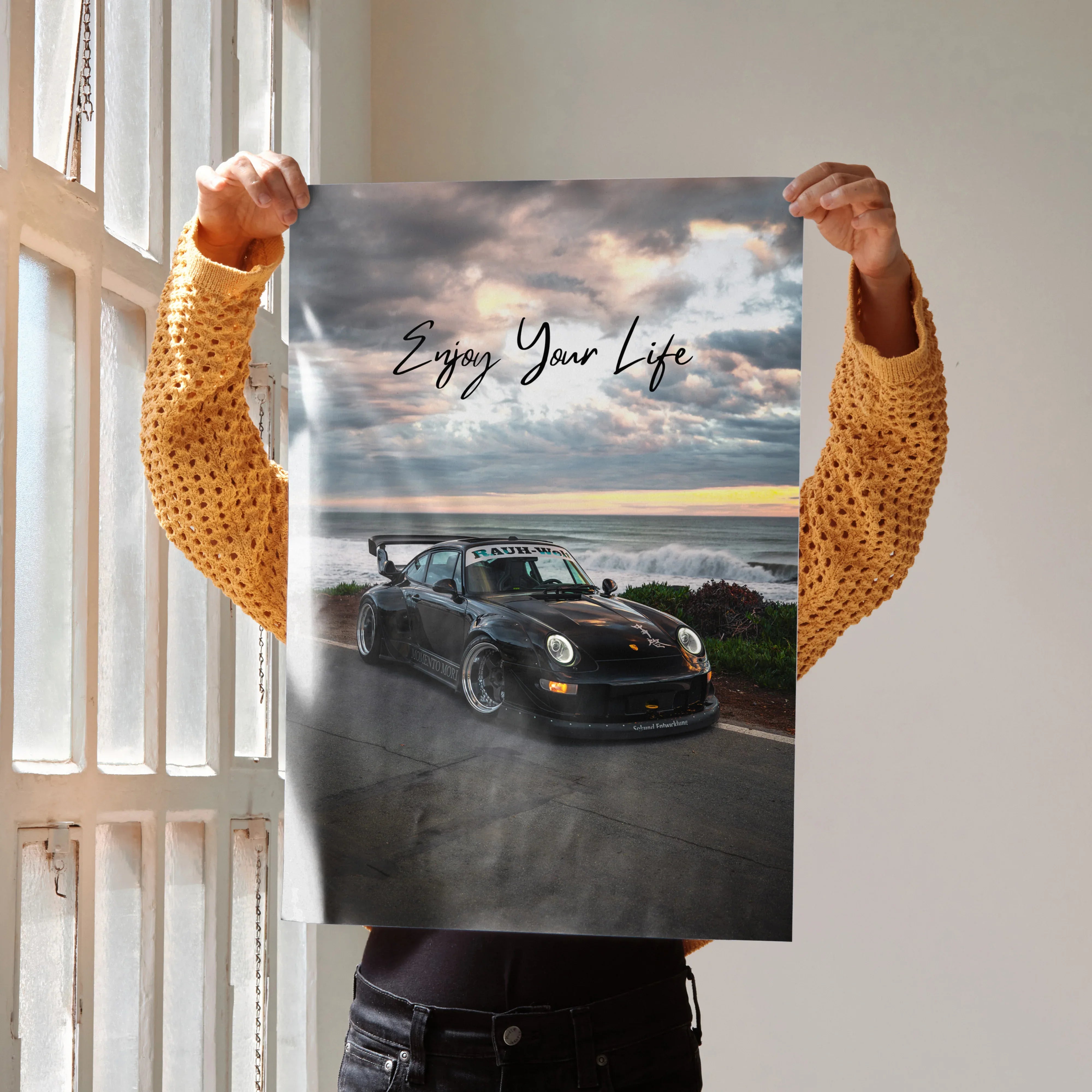 Motivational poster wall art featuring black RWB Porsche 911 with "Enjoy Your Life" text over coastal sunset background.