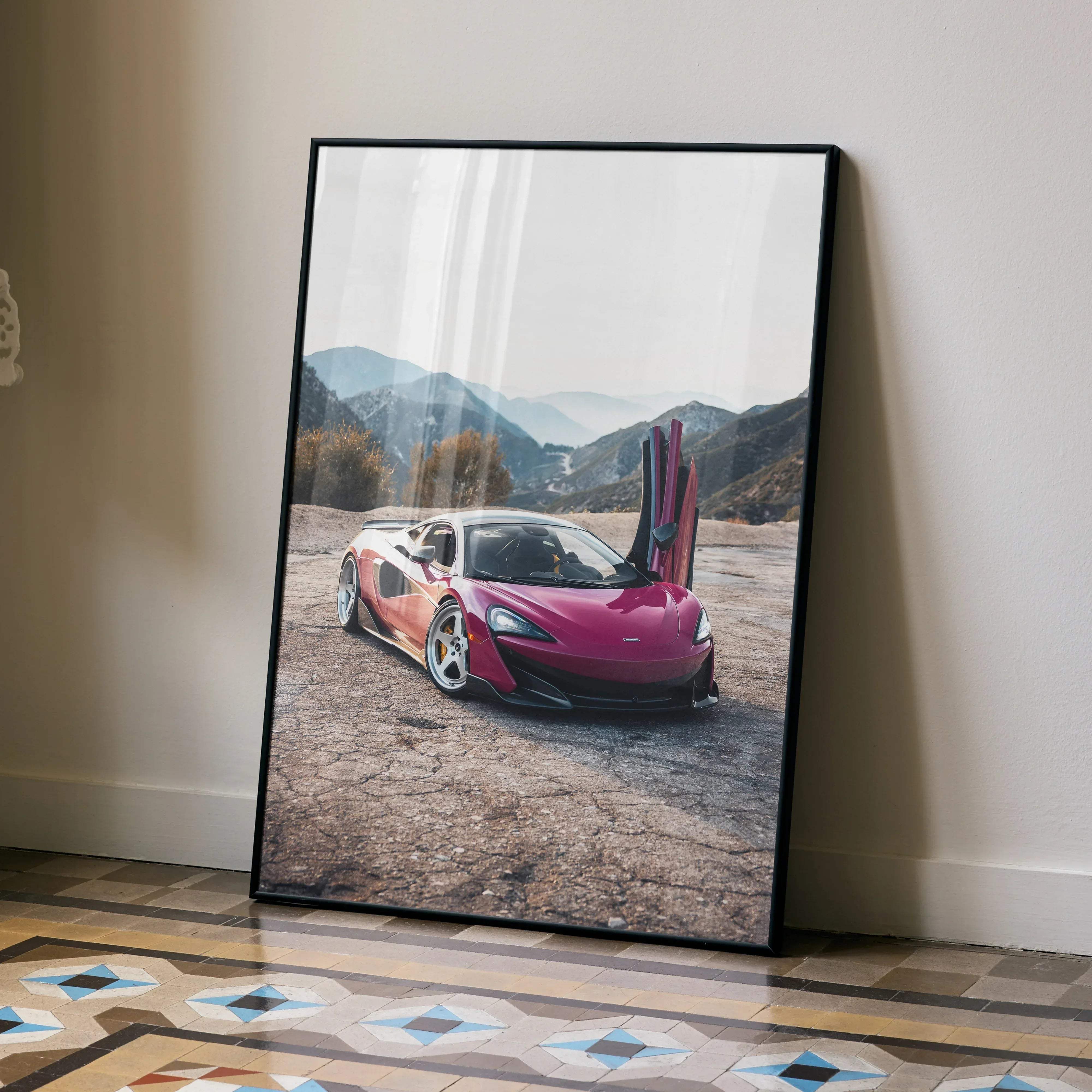 A framed McLaren 600LT high resolution car poster featuring a vibrant pink sports car with open doors and mountains