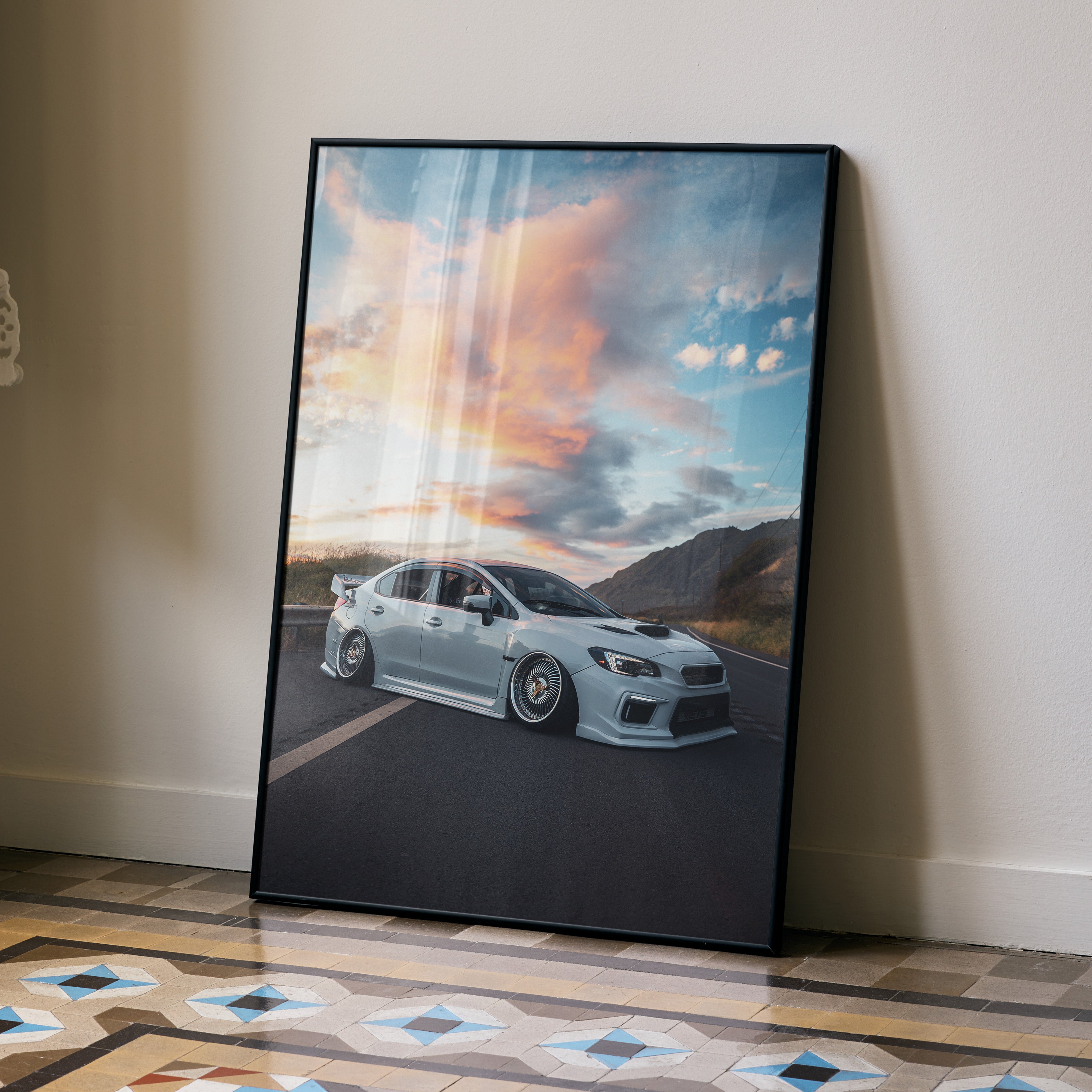 Subaru WRX car parked on road at sunset poster wall art with dramatic sky and mountains.