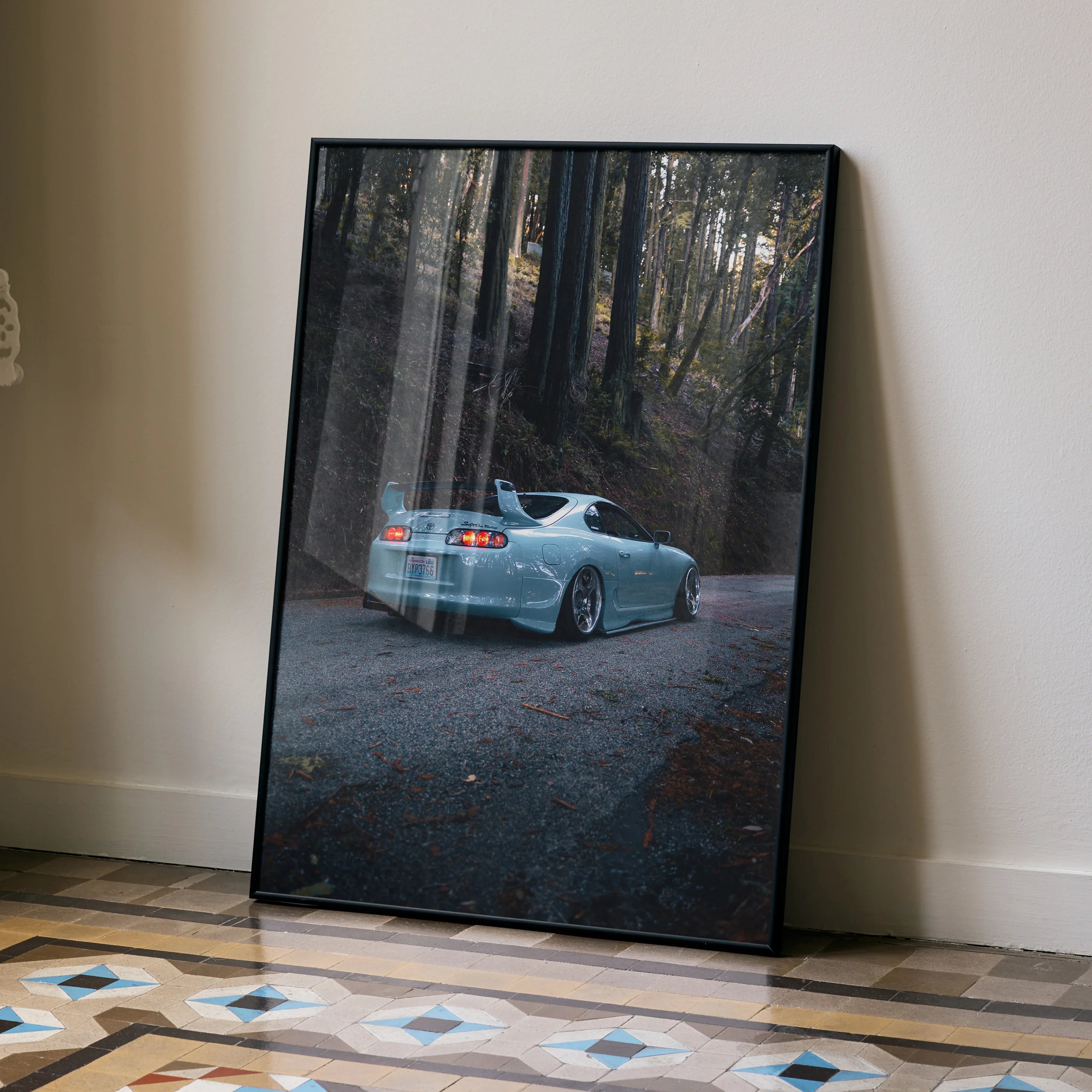 Toyota Supra Mk4 in forest setting Poster with sleek silver sports car Wall Art in black frame.