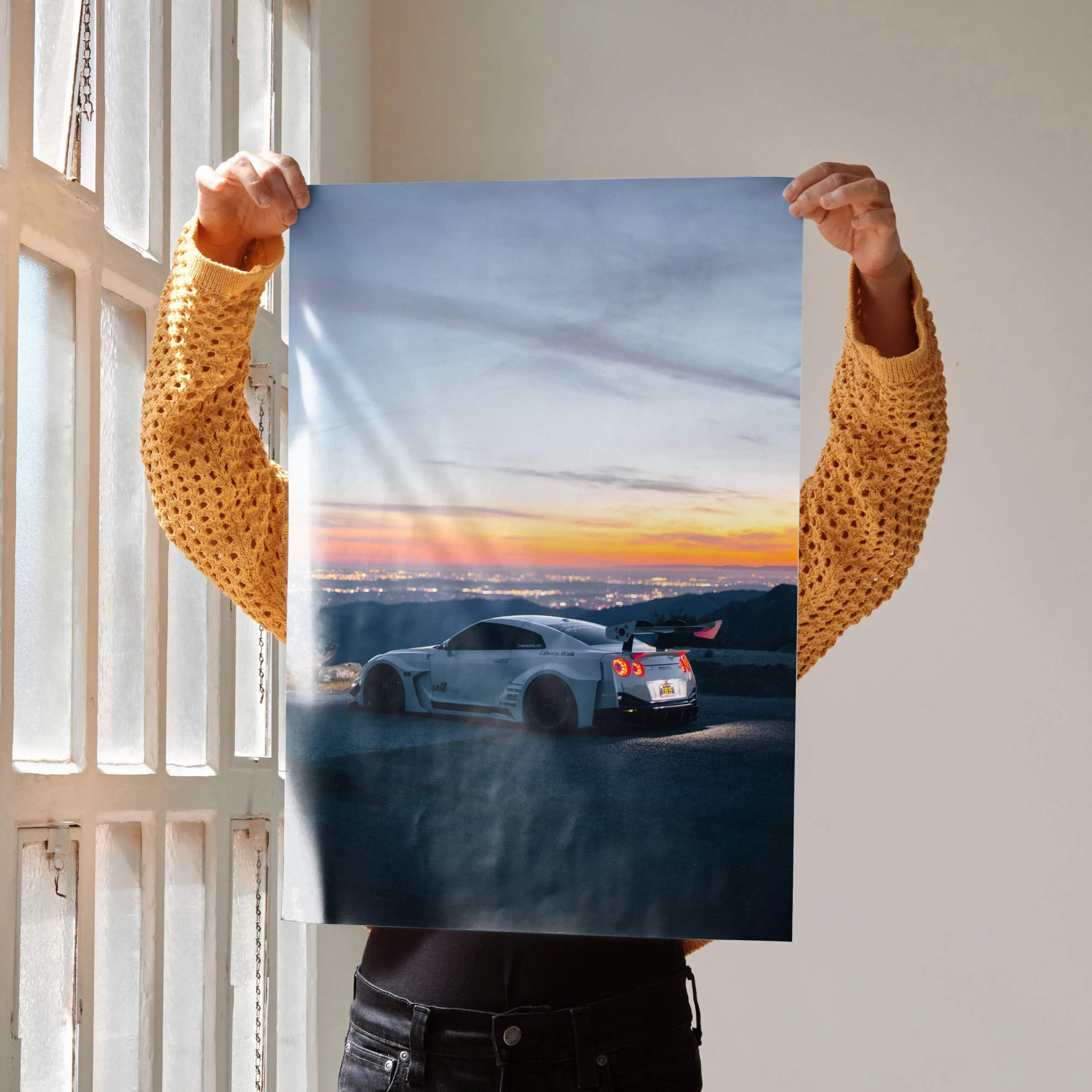 A sleek white Nissan R35 GT-R sports car poster showing the dynamic rear view with glowing taillights and smoke effects