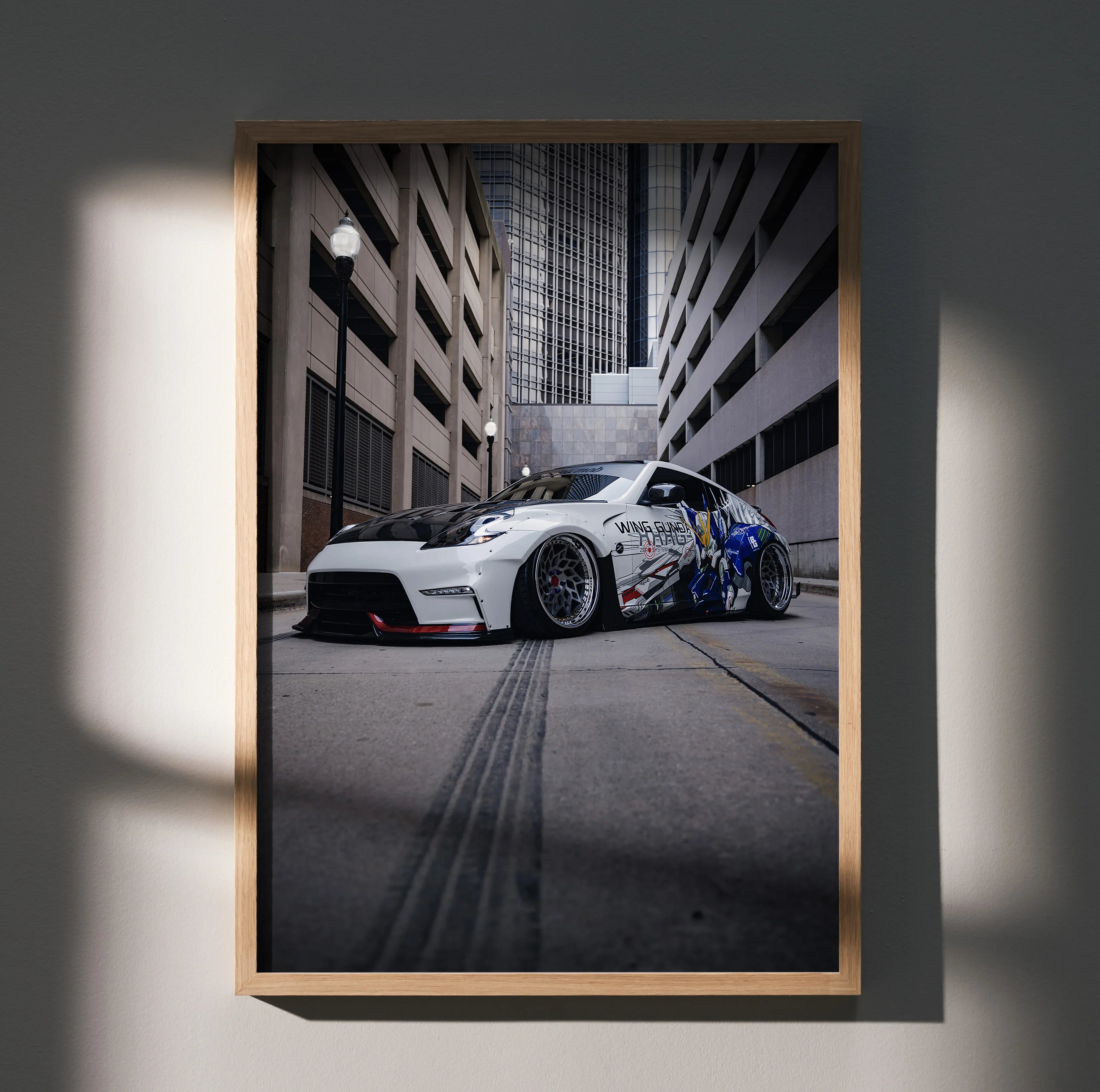 Nissan 370z in silver with blue decals parked between tall buildings, poster wall art in premium satin finish.