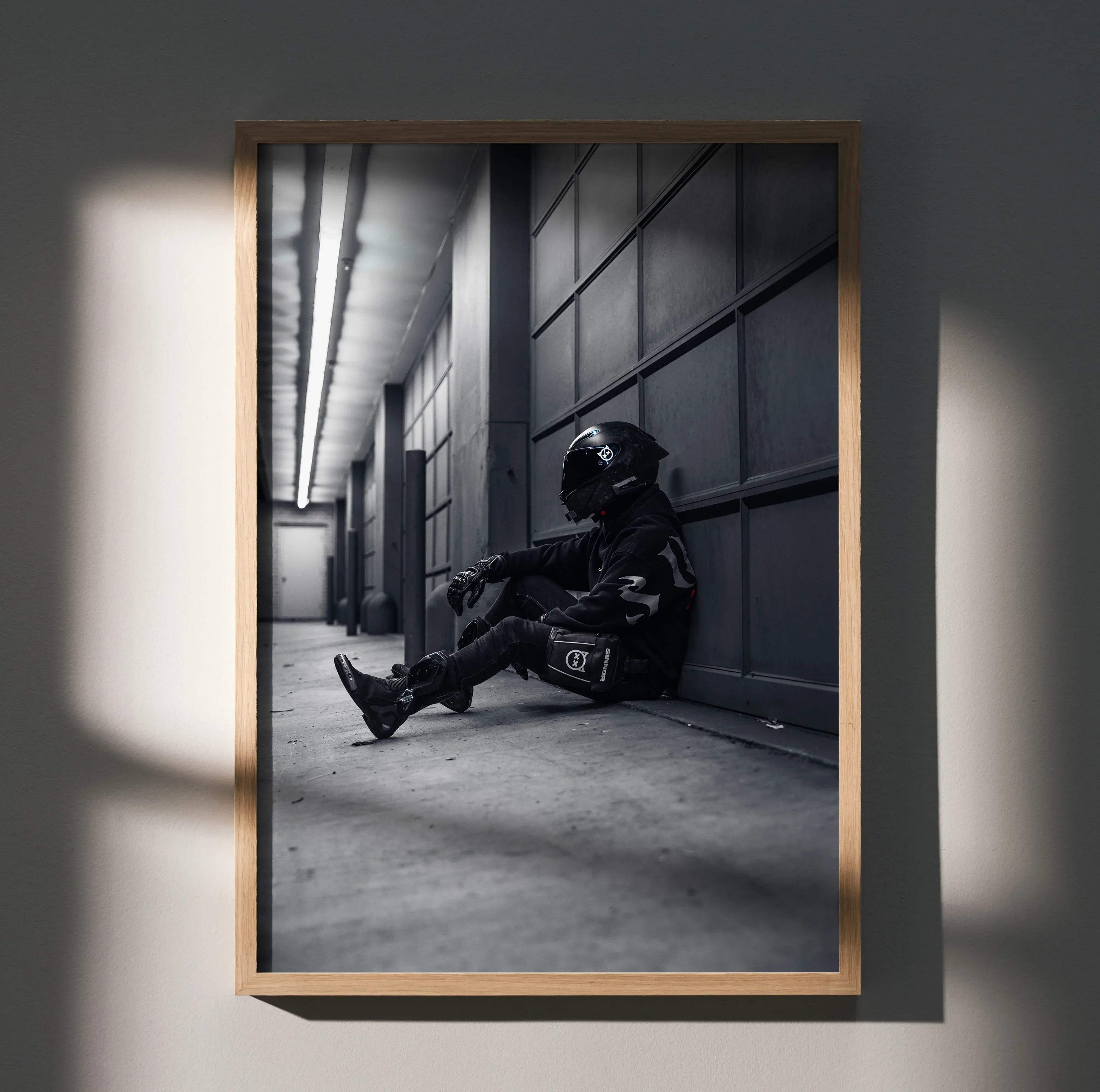 Male rider wearing black agv pista helmet with white logo sitting in full gear against garage wall on yamaha r6 motorcycle