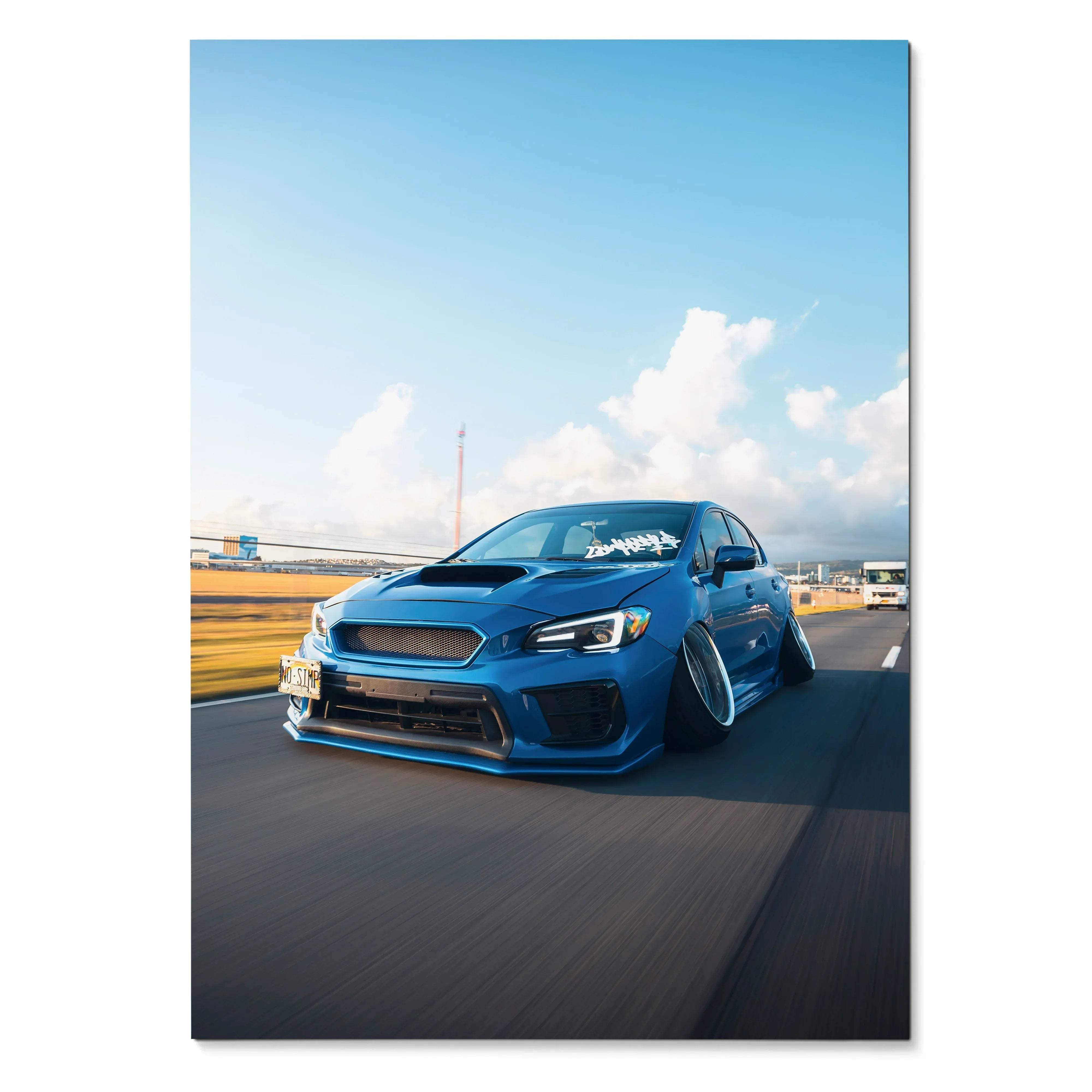 Blue slammed Subaru WRX driving on road poster wall art with clear sky background.