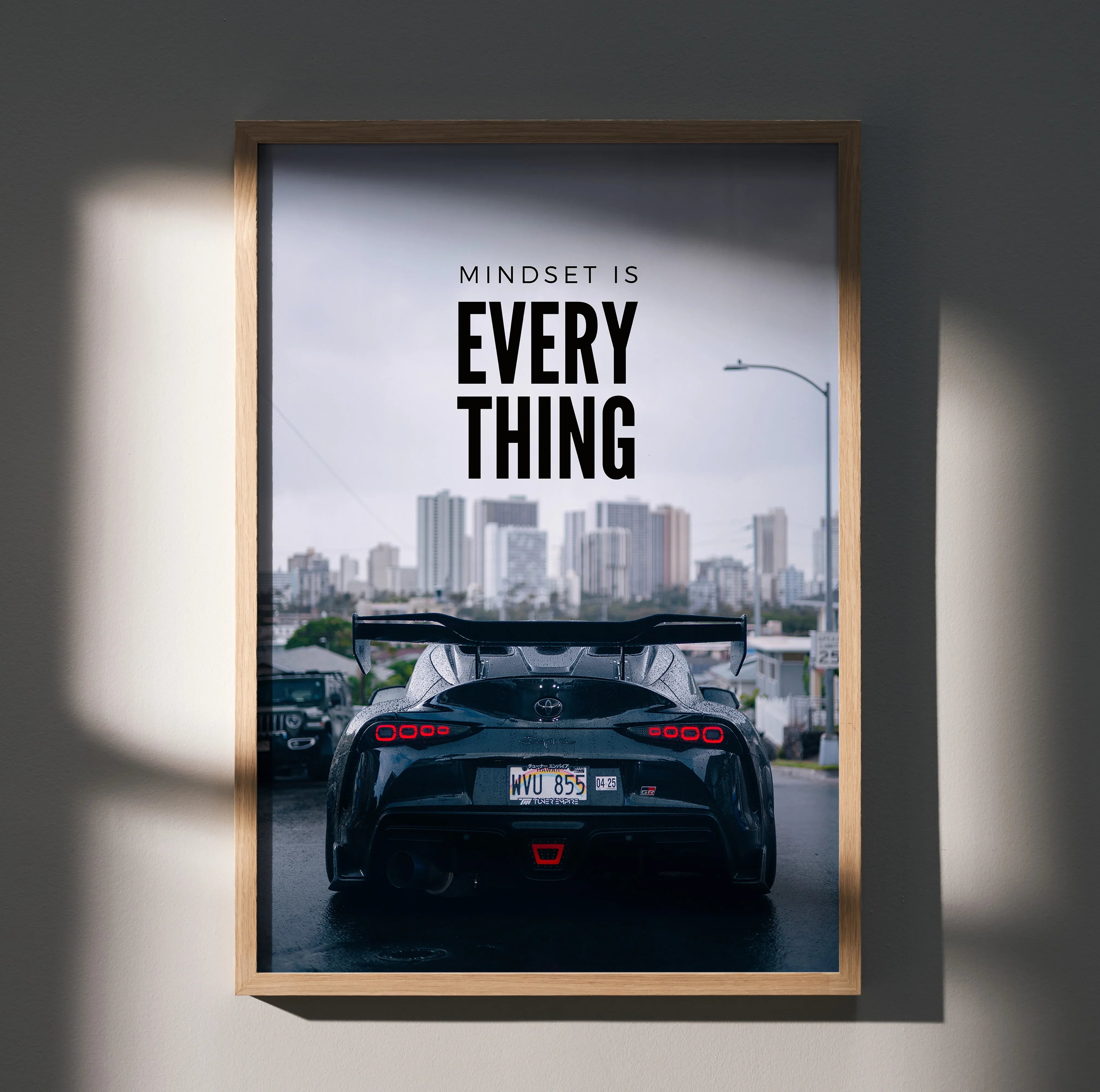 Motivational poster wall art featuring rear view of black Toyota Supra Mk5 with city skyline and inspiring text "Mindset is.