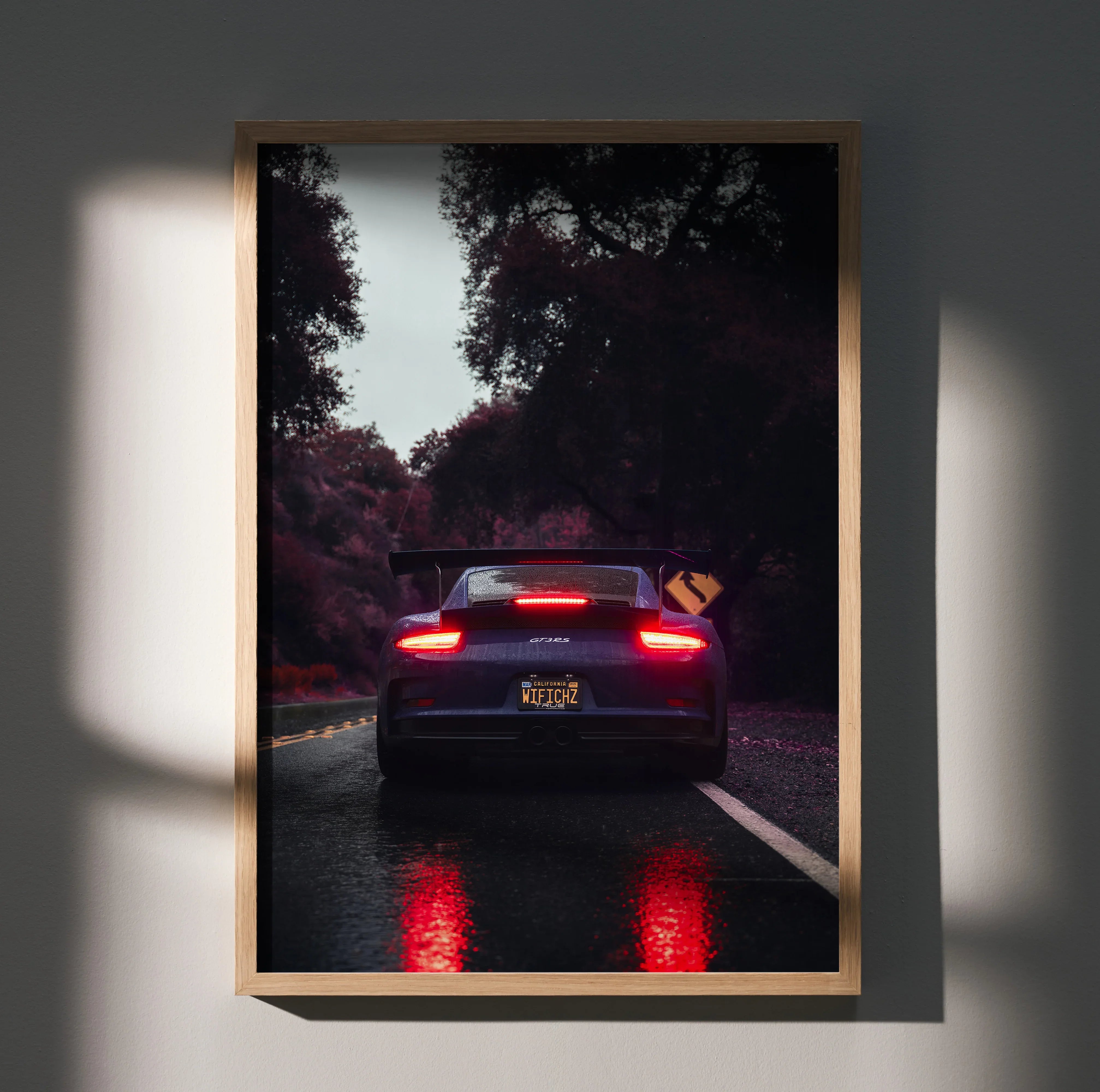Porsche 911 GT3 RS rear view poster with glowing taillights on wet road wall art in wooden frame.