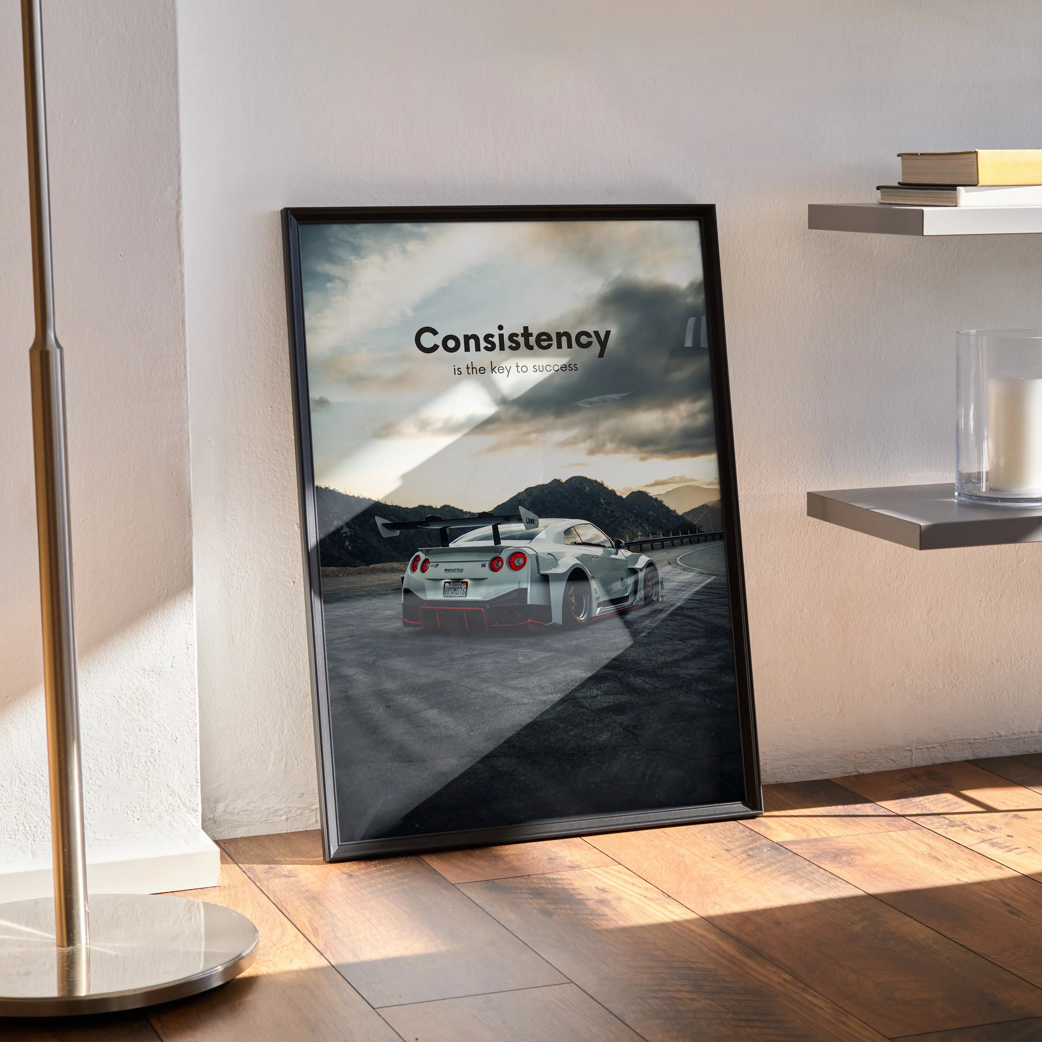 Motivational poster wall art featuring Nissan R35 GT-R on scenic road with "Consistency" text in black frame.