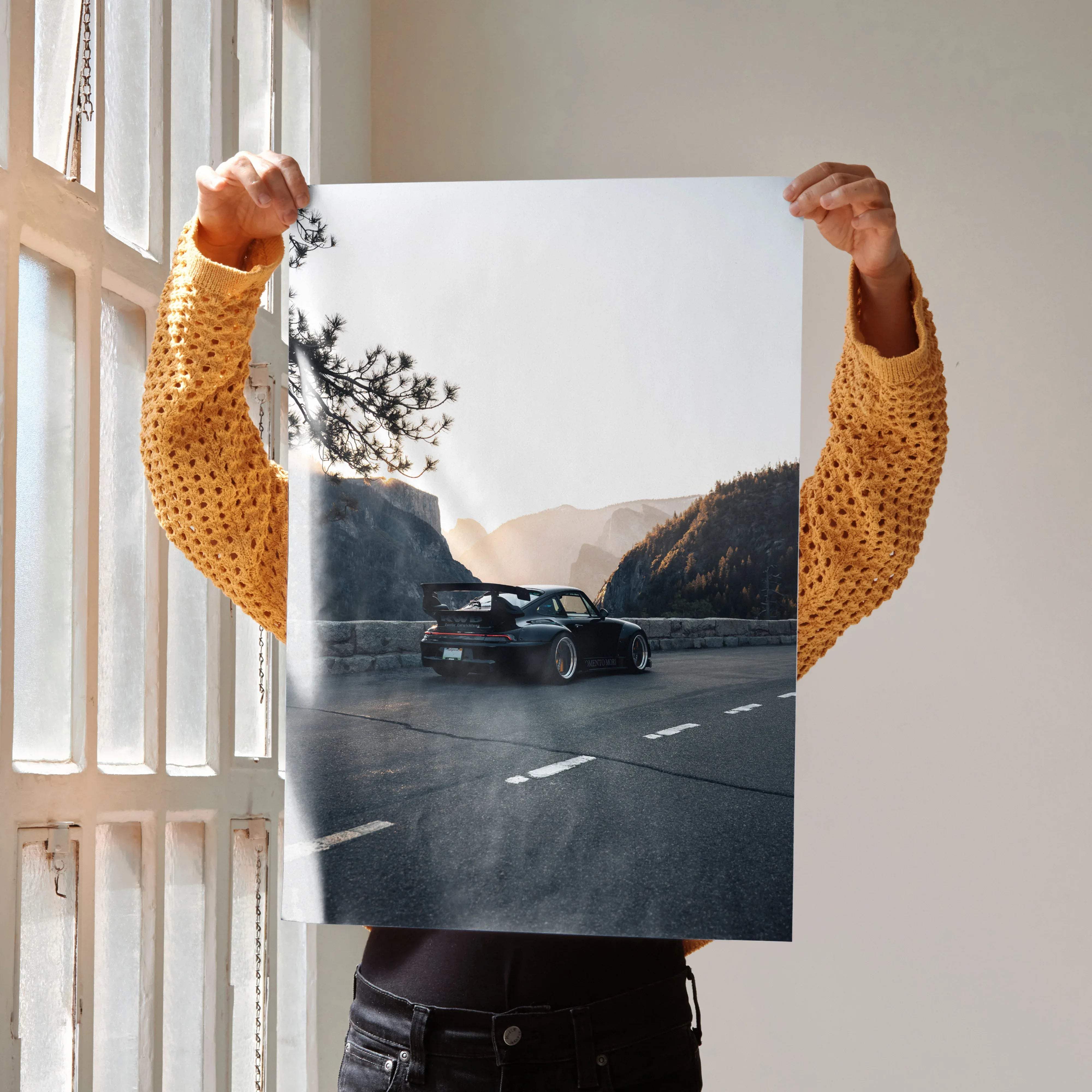 A black porsche 911 sports car with rear spoiler and custom wheels on a winding mountain road in high resolution wall art poster