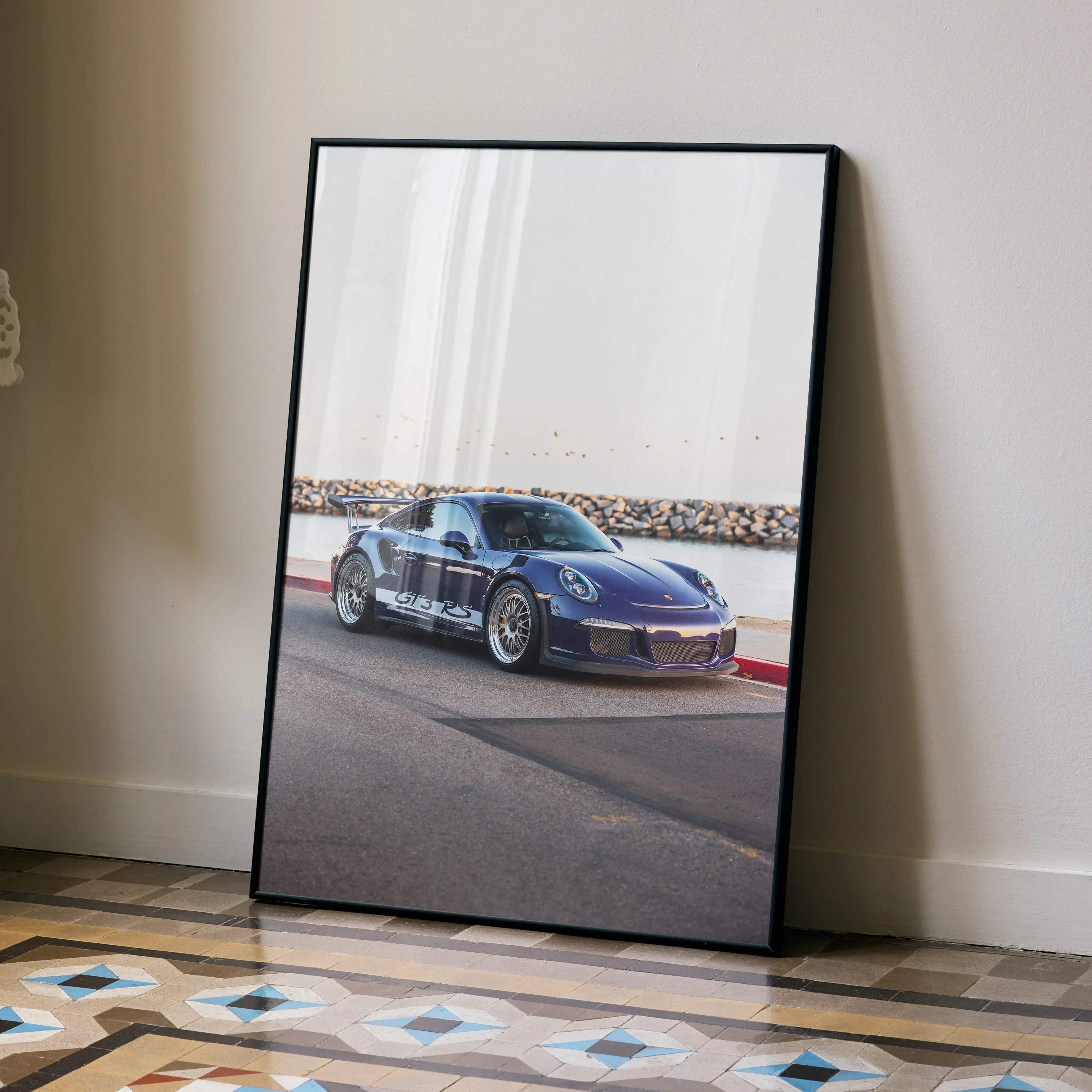 A framed photograph of a blue Porsche 911 GT3 RS sports car in motion on a coastal road high resolution poster