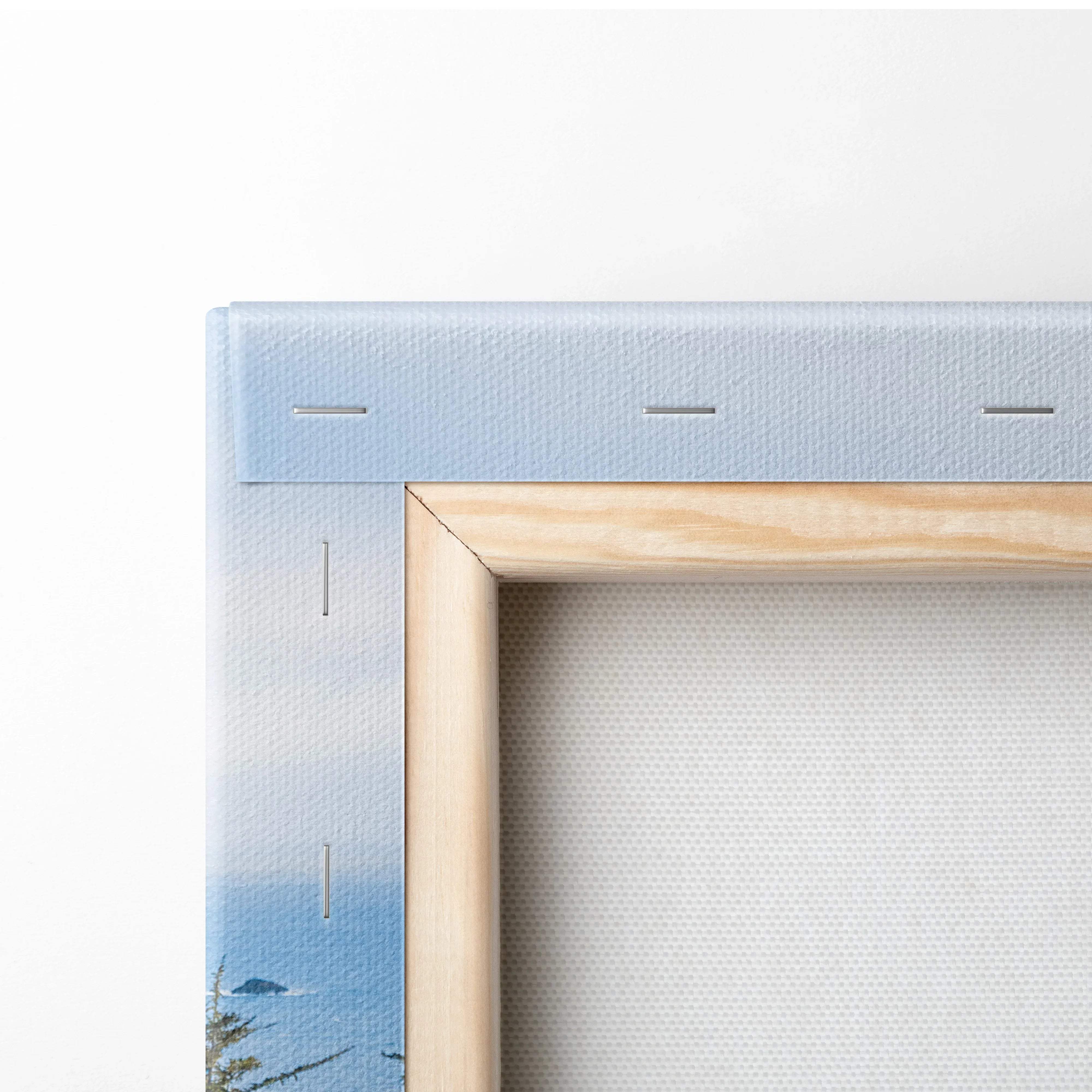 Back of light blue canvas with wood frame and stitching, rugged coastal cliffs art