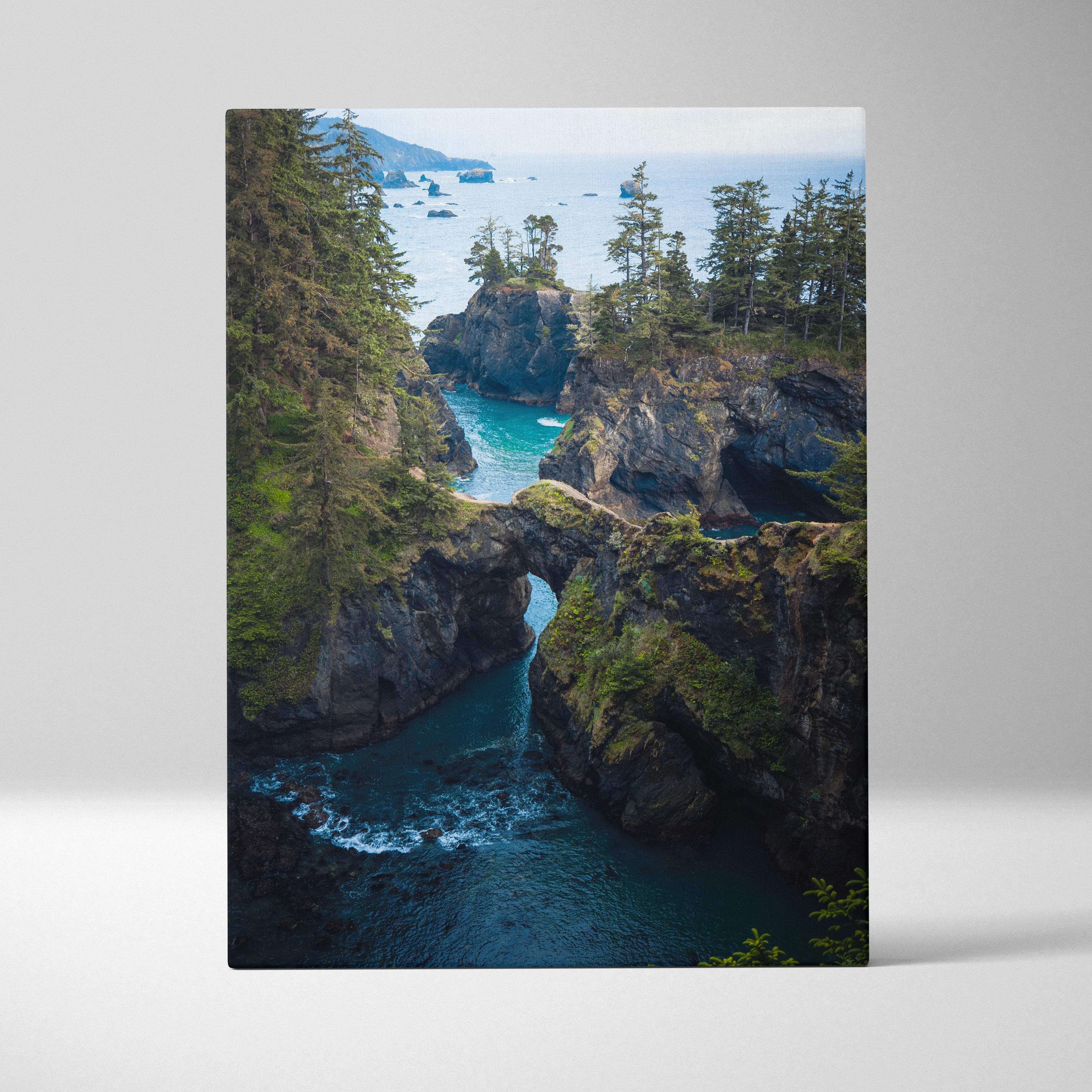 Rugged coastal cliffs with rock arch over emerald water canvas print