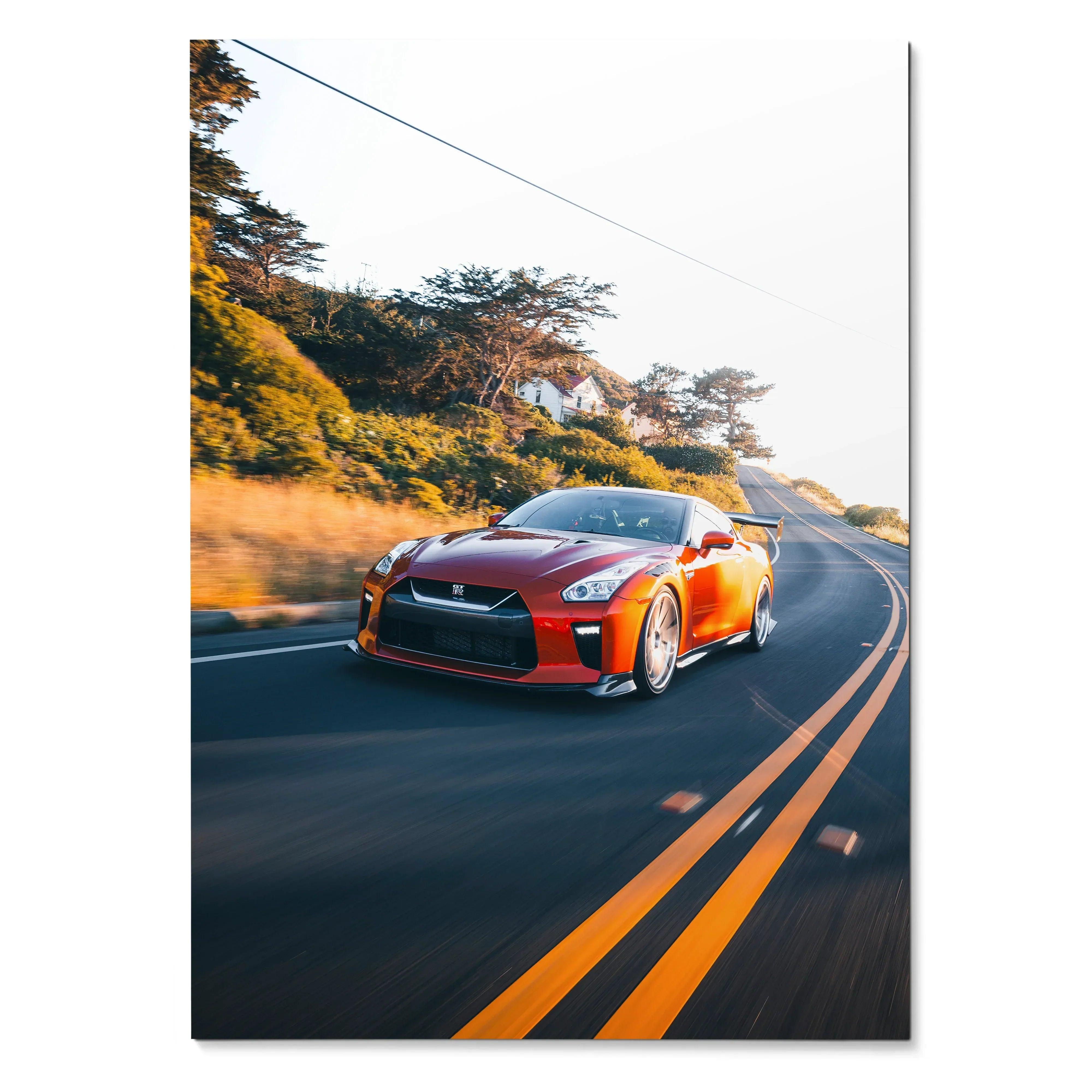 Nissan R35 GTR driving on winding road at sunset poster wall art in vibrant orange and black colors.