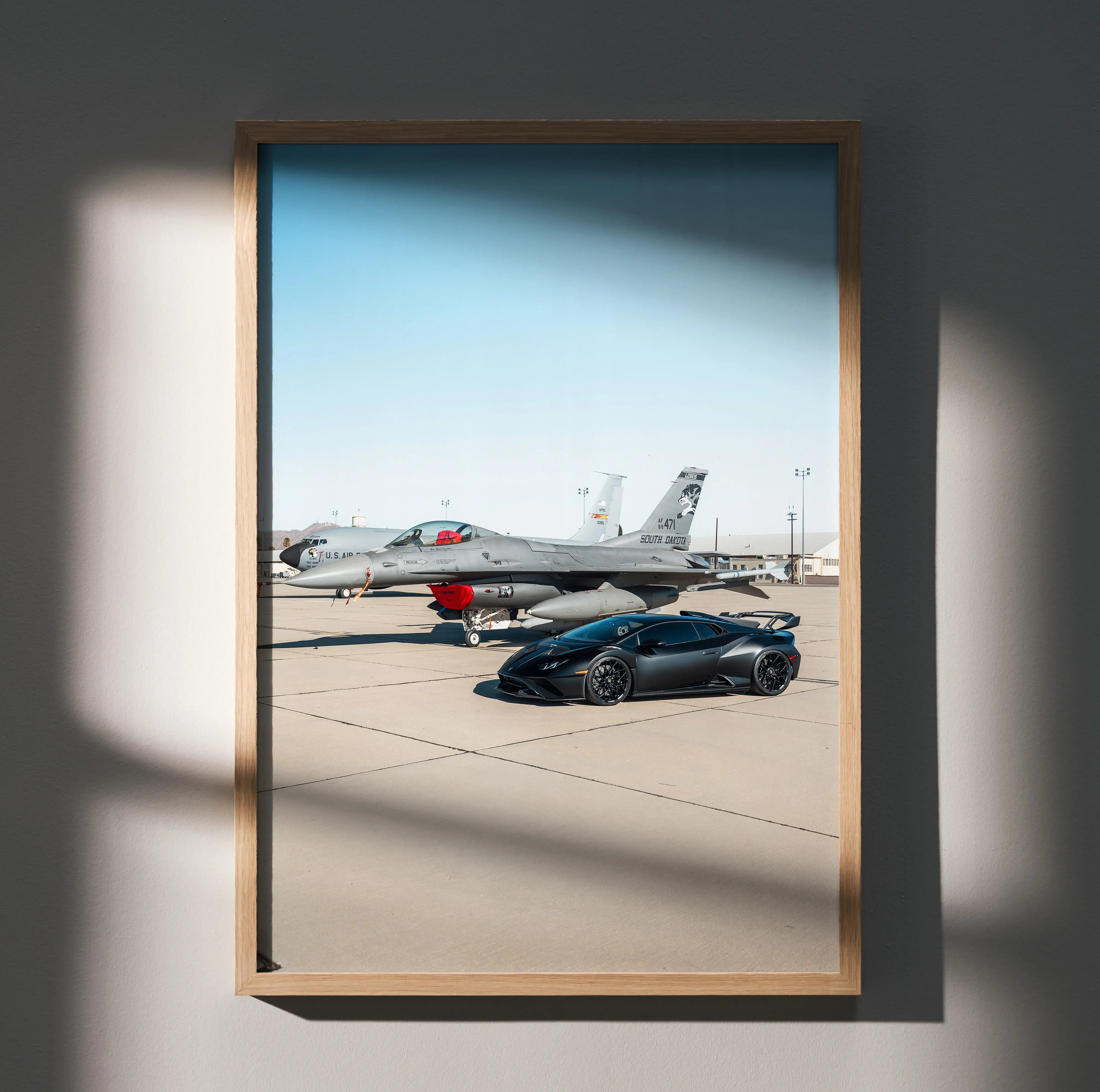 Lamborghini Huracan STO poster with sleek black car parked on runway near a jet, luxury wall art.