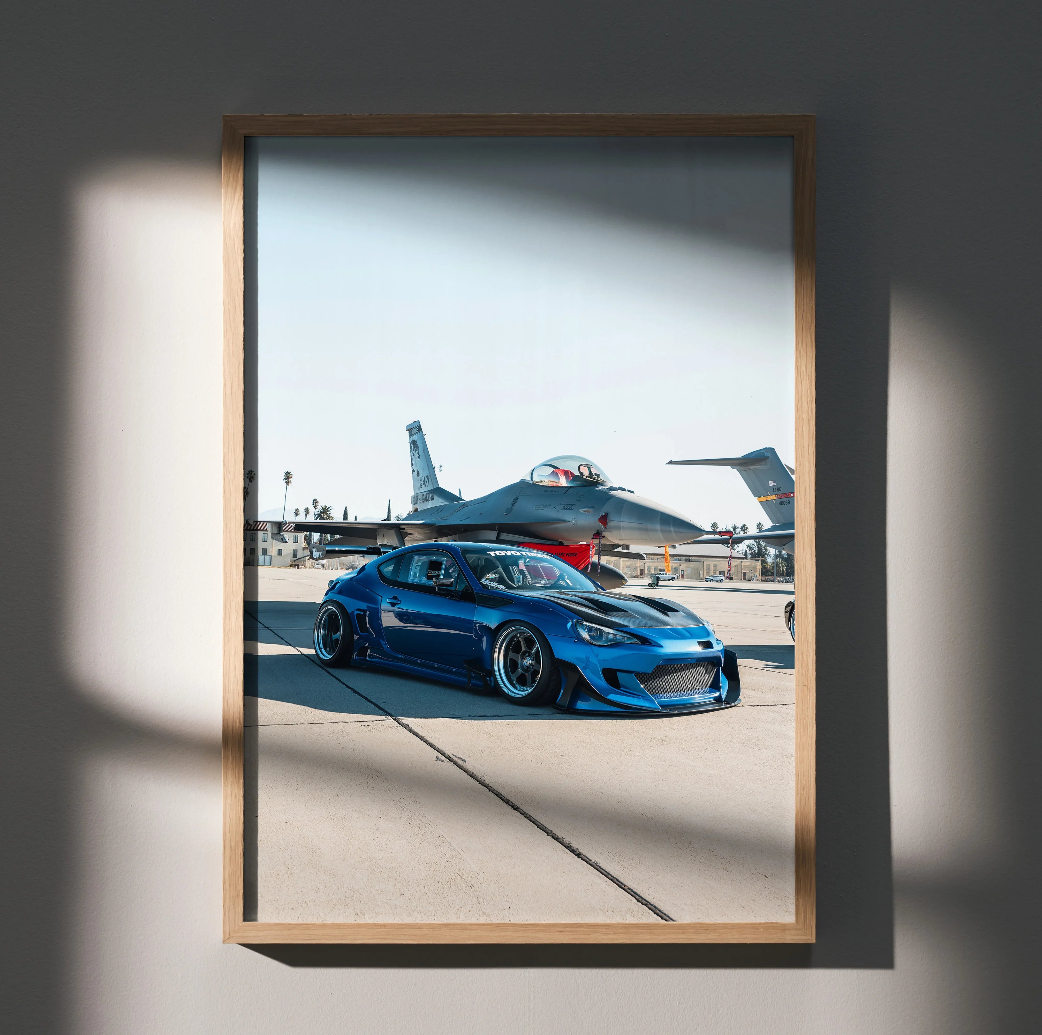 Sleek modified blue Toyota FRS car poster with aircraft background wall art in wooden frame.