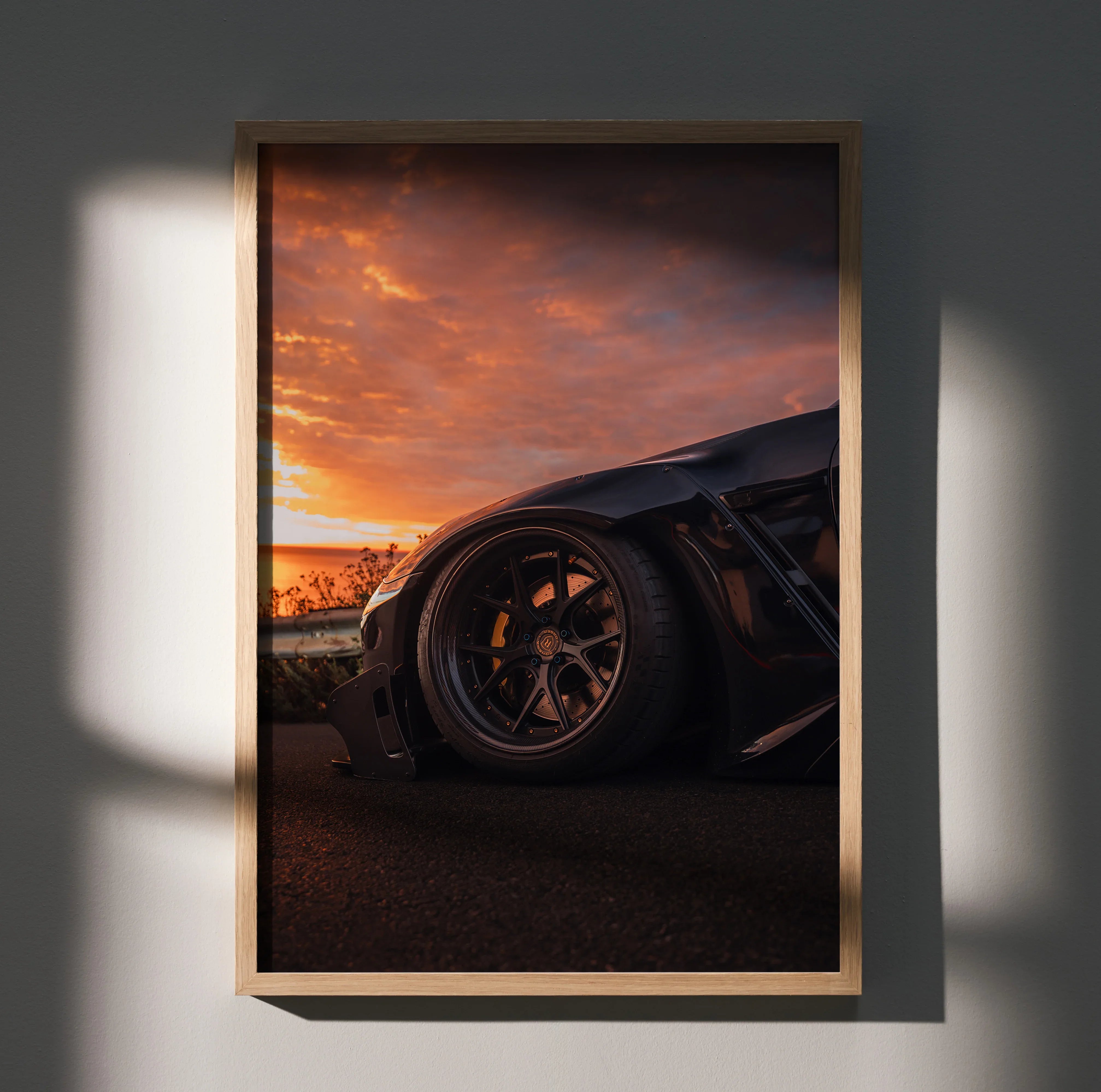 Sleek Nissan GTR R35 poster wall art with dramatic sunset and detailed car wheel close-up.