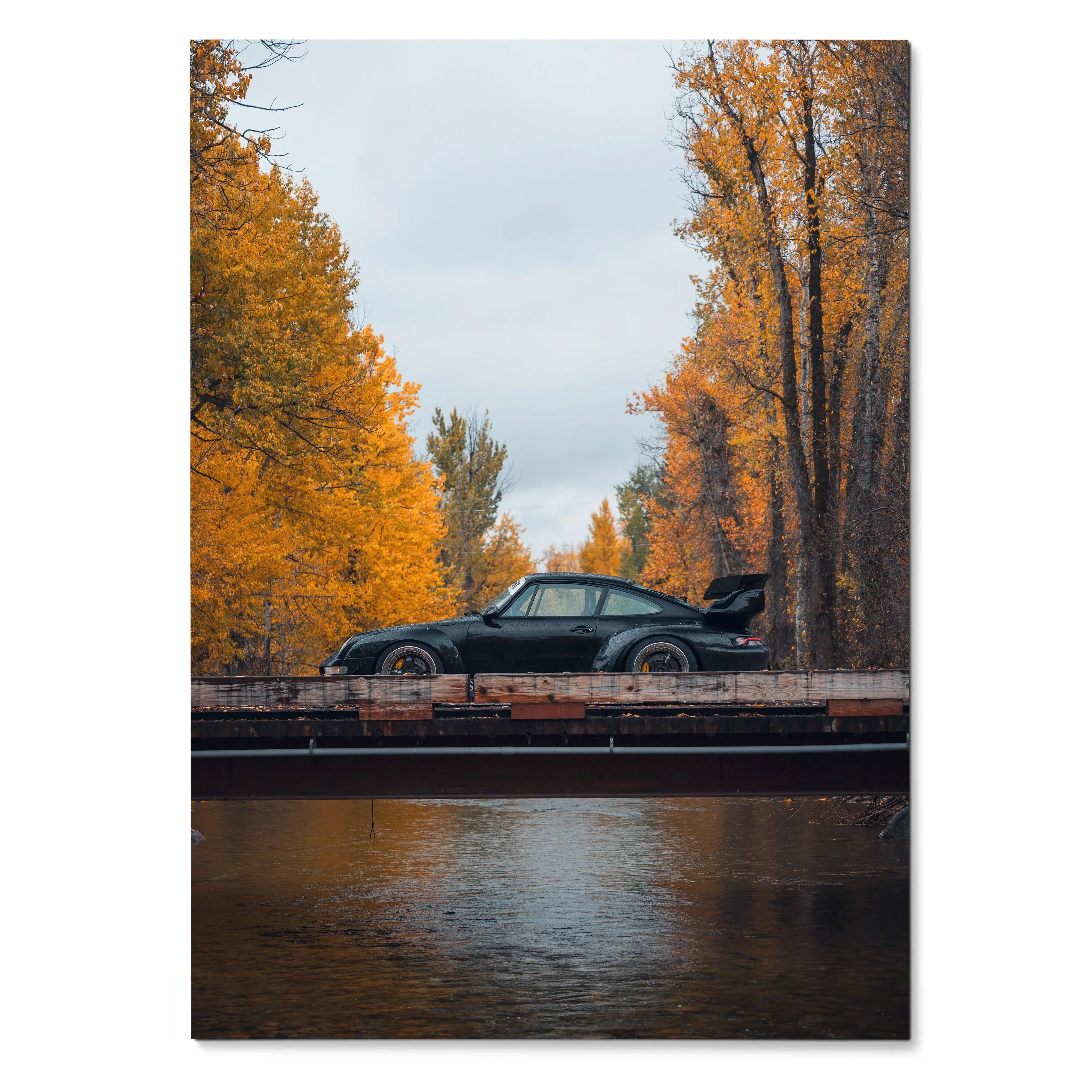 RWB Porsche 911 poster wall art with black car on bridge framed by autumn trees and reflective water.