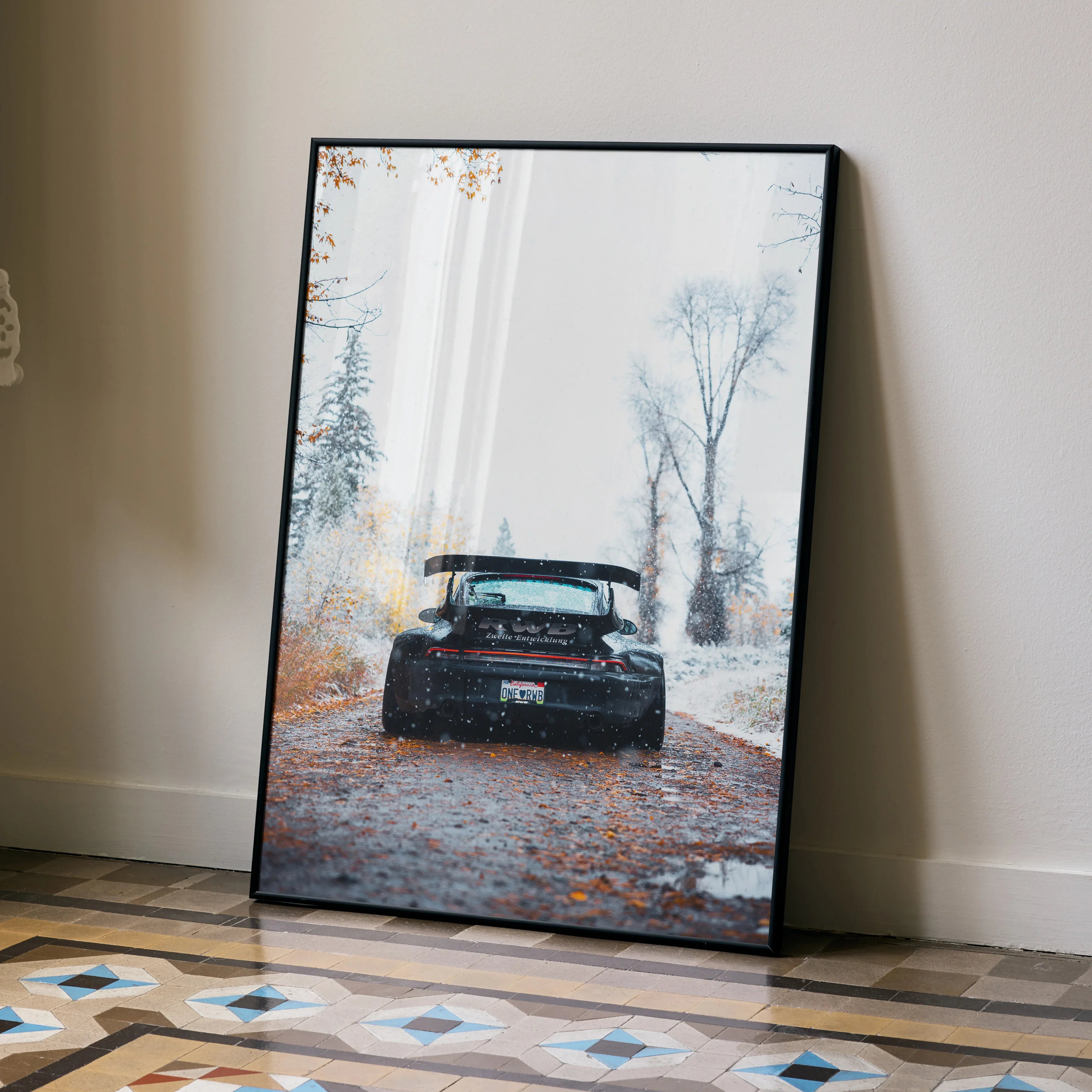 RWB Porsche 911 black car poster leaning against beige wall with autumn trees scene wall art.