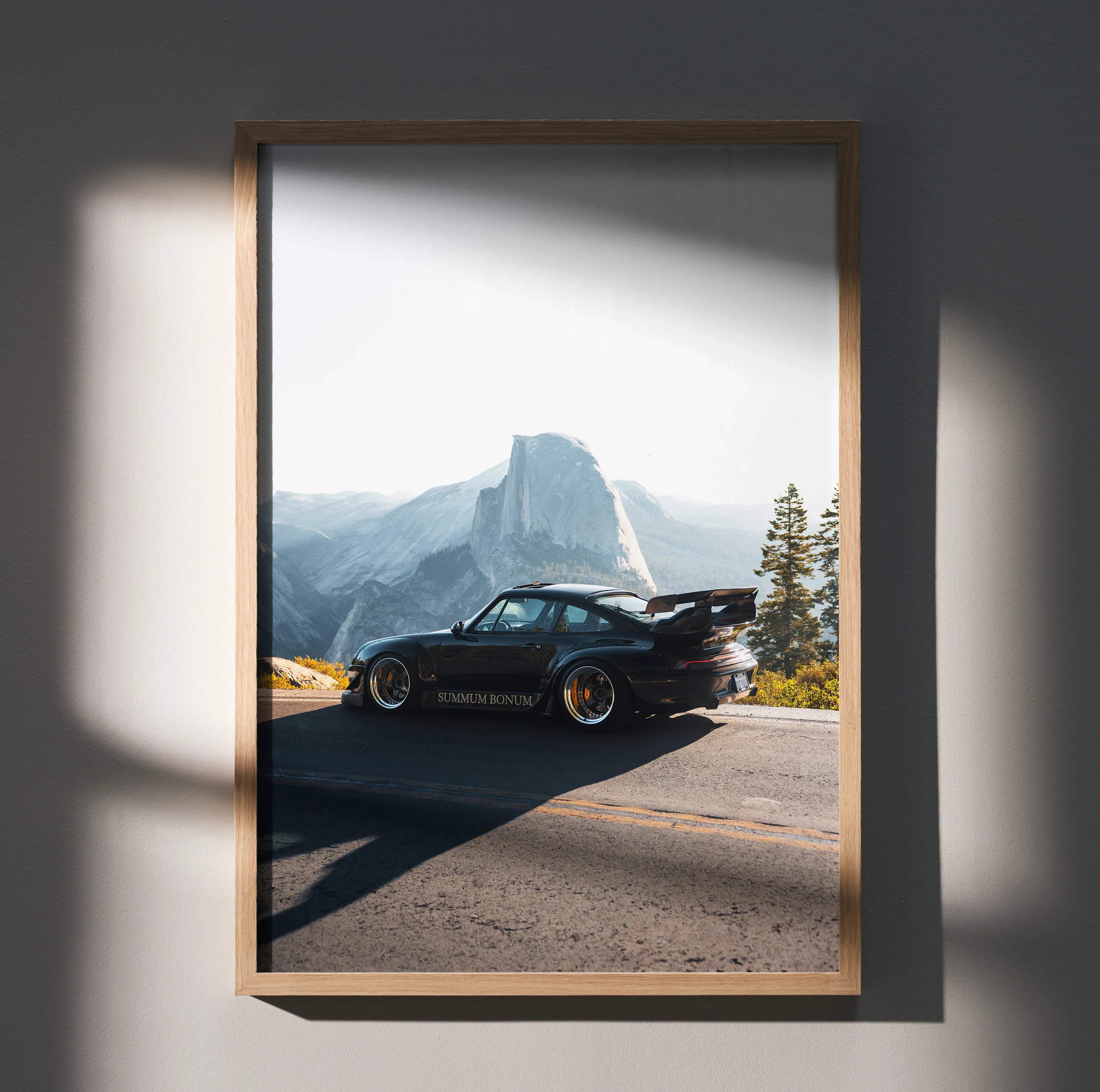 Rwb porsche 911 art print featuring a black car with gold rims and rear spoiler framed in light wood for wall decor