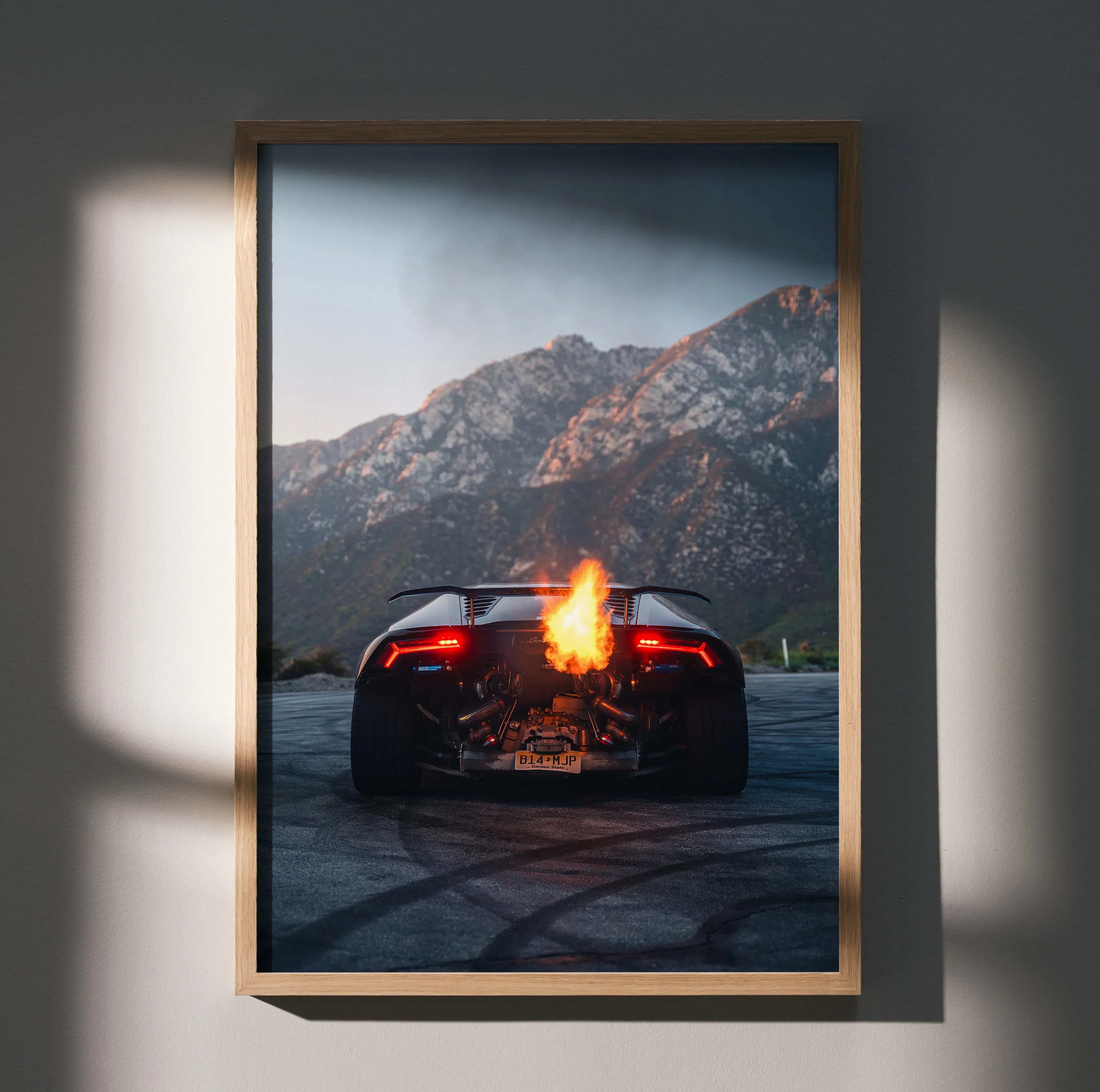 Lamborghini Huracan wall art poster with fiery flames and mountain backdrop in wooden frame.