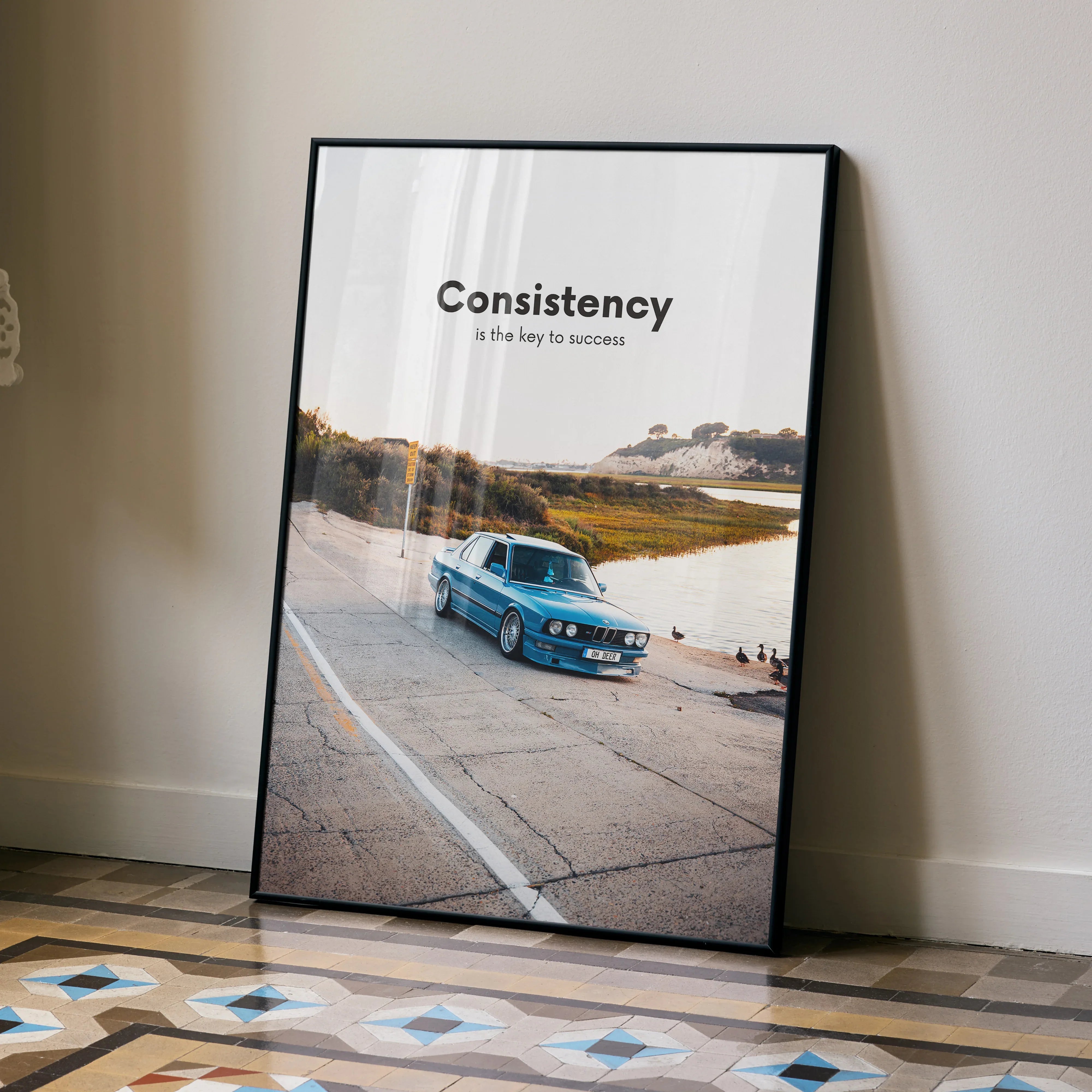 Motivational poster wall art featuring a blue BMW E30 on a road with the word "Consistency" and an inspiring message.
