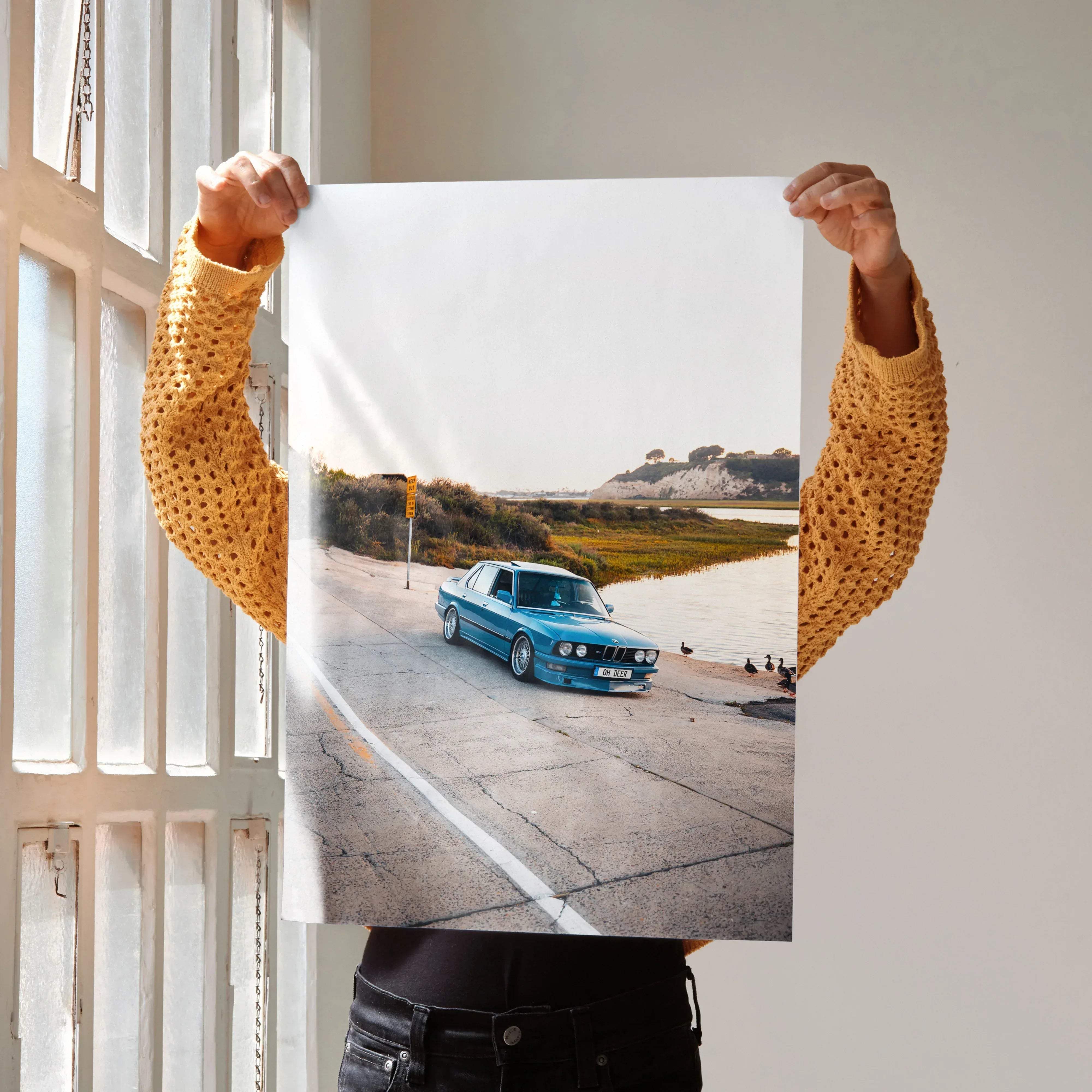 A vibrant turquoise bmw e30 sedan in a dynamic roadside pose for a high resolution classic car art print poster