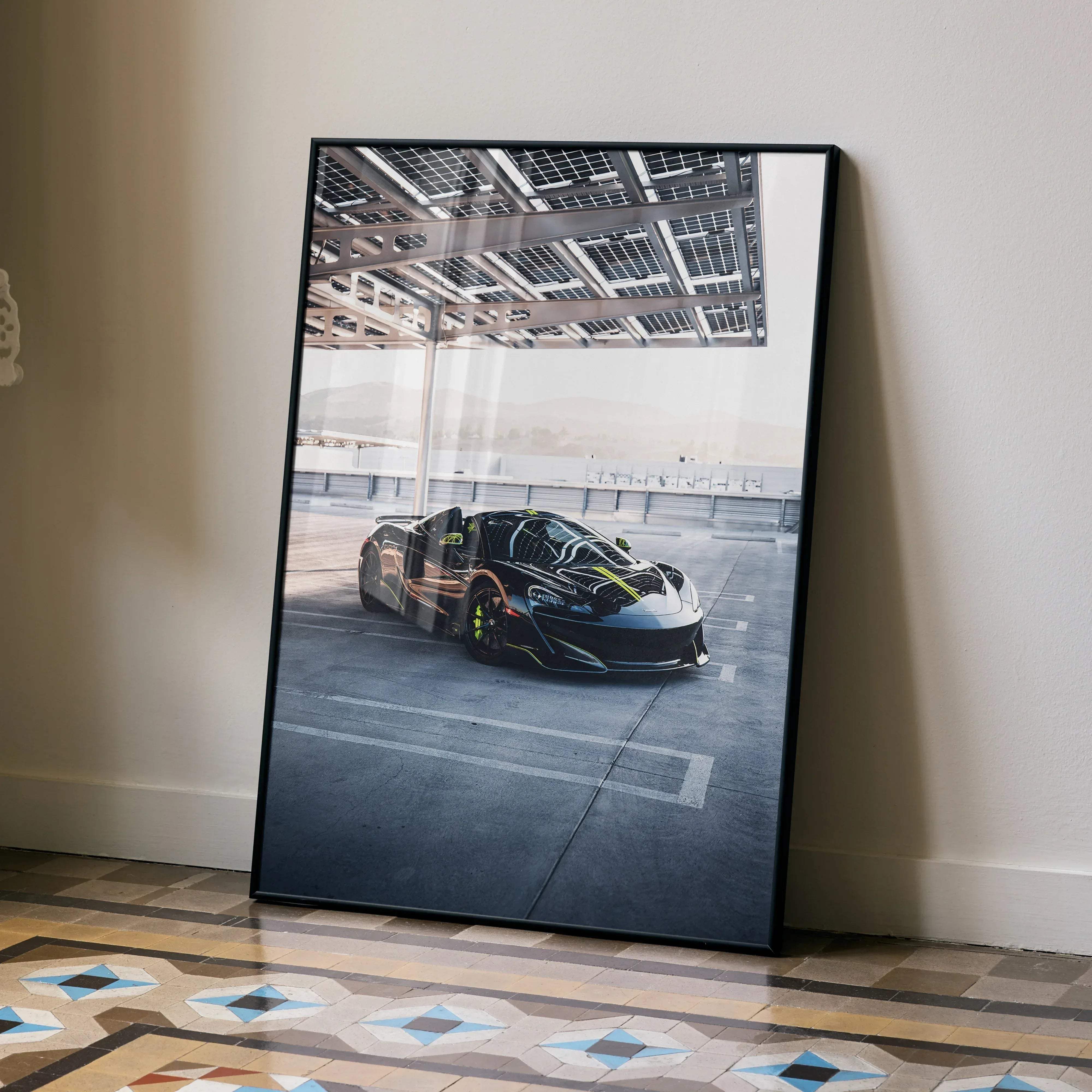 Black-framed poster featuring sleek black mclaren 600lt supercar with neon green accents under solar panel canopy