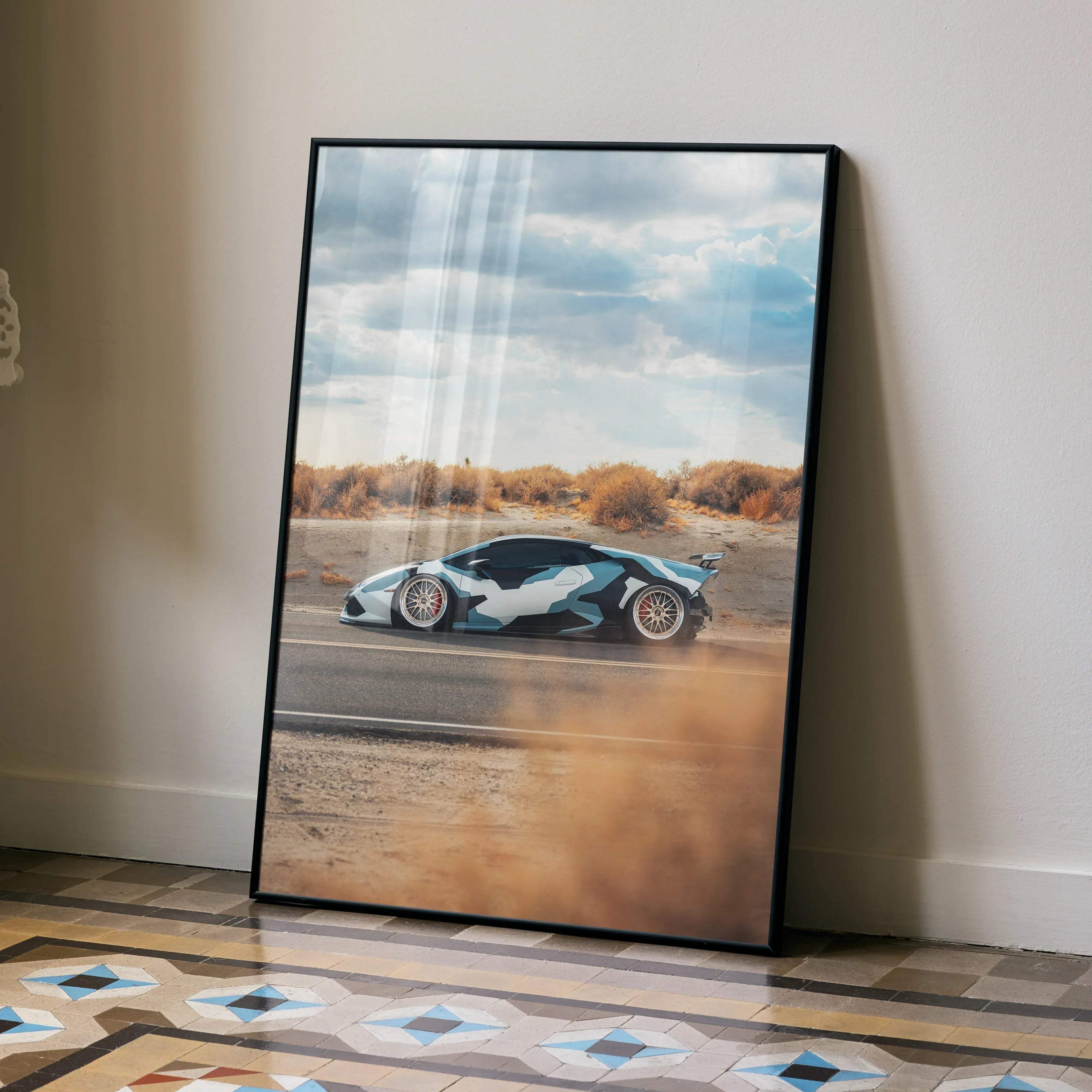 A framed Lamborghini Huracan high resolution car poster featuring a blue and white camouflage paint scheme leaning against a wall